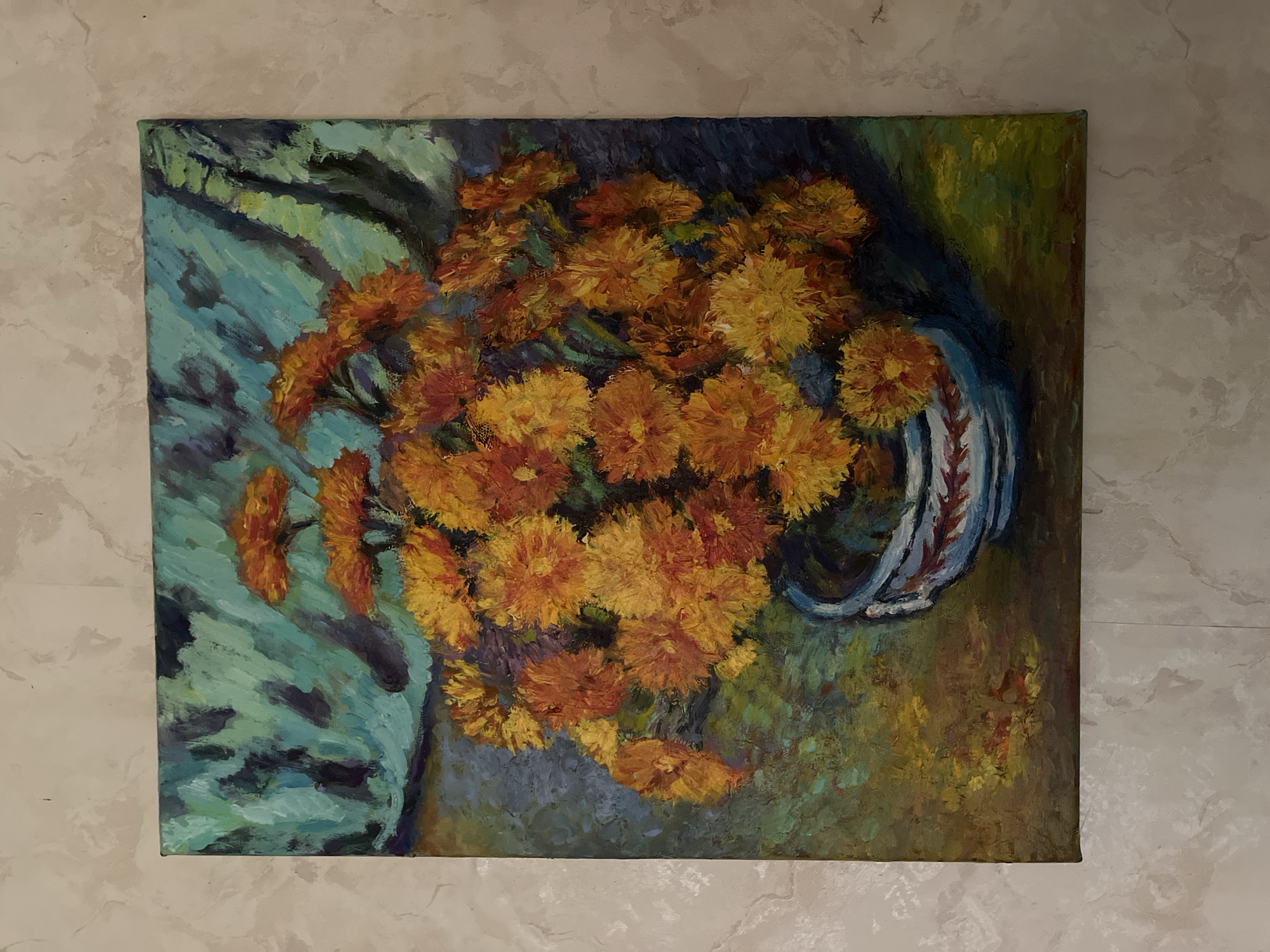 The image shows an oil painting of a bouquet of orange and yellow chrysanthemums in a blue and white striped vase. The background is a swirling pattern of teal and dark blue. The painting is placed on a wall with a marble-like texture. The image does not contain any information about the city of Starye Politsy, Russia.