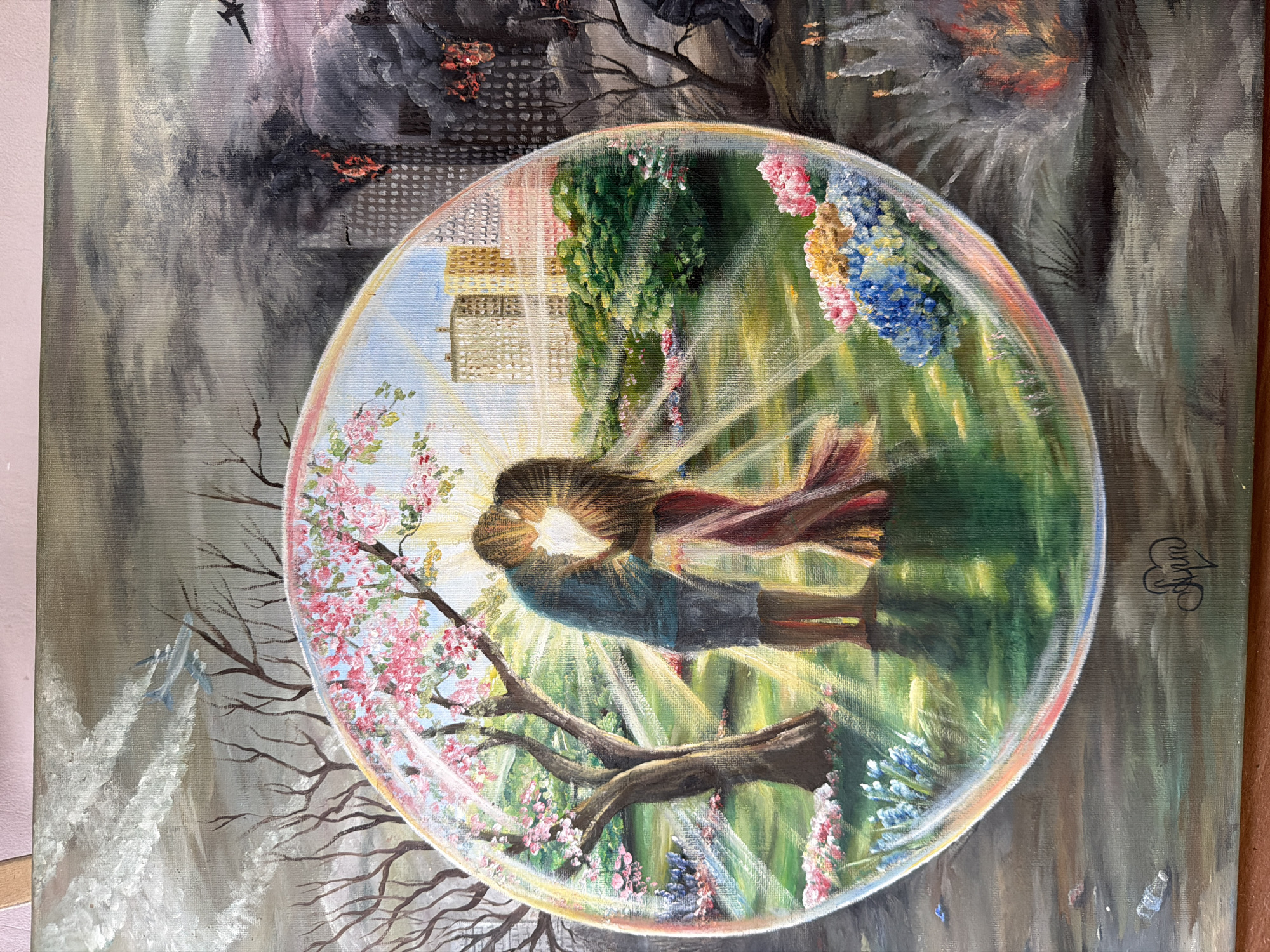 This is an oil painting of a couple kissing, enclosed within a circular bubble. The bubble is set against a backdrop of a dystopian scene with a city in flames and smoke, and planes flying overhead, suggesting a war or disaster. Inside the bubble, the scene is idyllic. It depicts a vibrant, sunlit garden with blooming cherry blossoms and other flowers. Rays of sunlight emanate from the kissing couple, highlighting their embrace and casting a warm glow on the surroundings. The contrast between the chaos outside and the peace within the bubble is stark. The time of day appears to be daytime, as indicated by the strong sunlight. The location context of Sochi, Russia, is not directly visible within the painting's imagery but is provided. There is a signature in black ink on the right side of the painting.