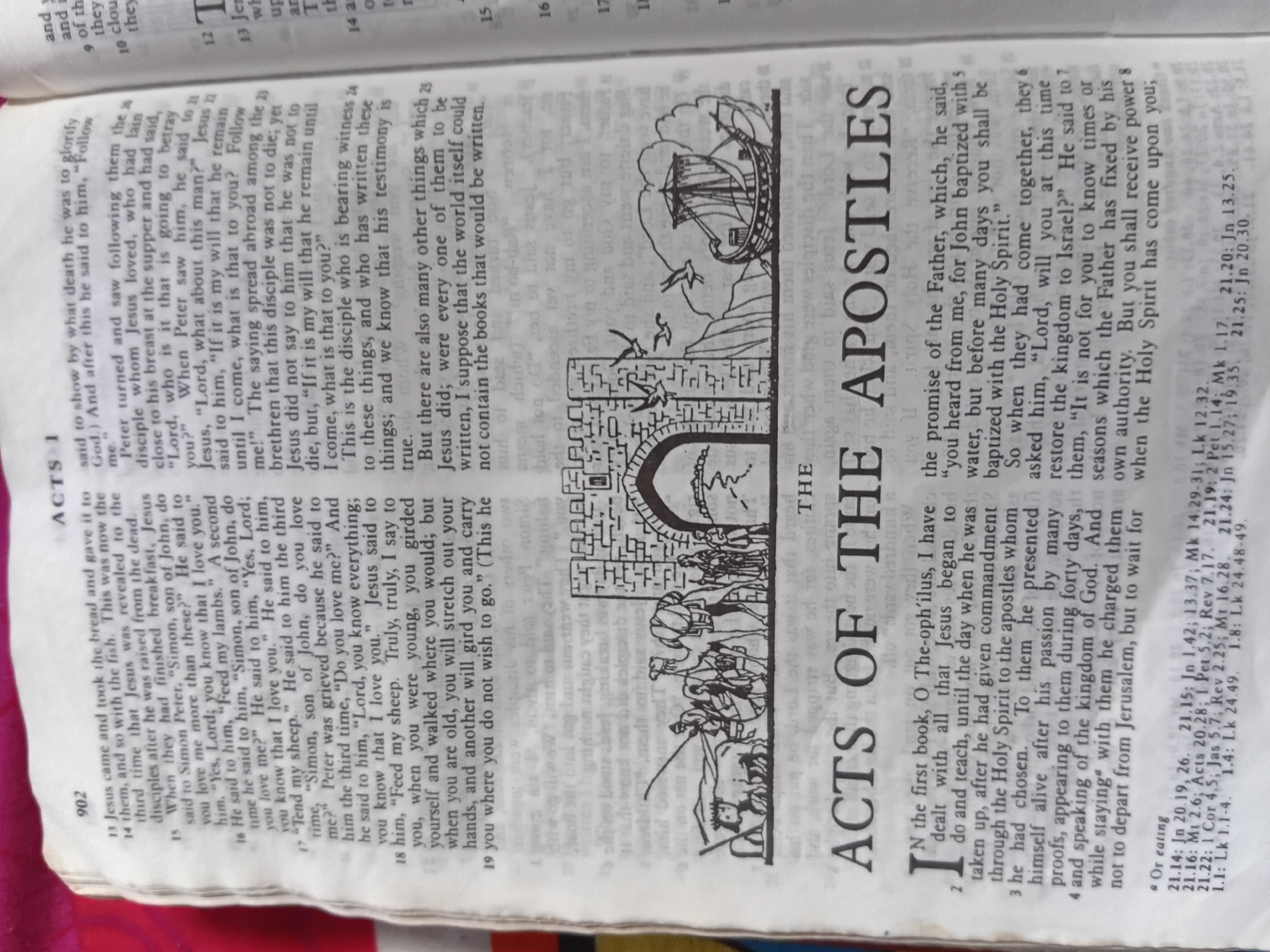 The image shows an open Bible, revealing a page with text and an illustration. The text is in English and appears to be from the book of Acts. The illustration depicts a walled city with an arched gateway, with several people and camels in front of it. A ship with sails is also visible in the background. The text is predominantly black ink on a cream-colored page, with some red ink for chapter headings and verse numbers. The illustration is in black ink.
The text includes verse numbers such as 902, and chapter headings like "ACTS 1" and "ACTS OF THE APOSTLES". Some of the text is also visible on the opposing page, including verse numbers like 13, 14, 15, 16, 17, 18, and 19. There is also a smaller section of text with red lettering that appears to be a footnote or cross-reference.
The scene appears to be set in a historical or biblical context, given the illustration and the nature of the text. There are no clear indicators of the time of day or weather conditions. The overall impression is one of a historical or religious document being presented. The image is cropped such that only a portion of the Bible is visible, with the focus on the text and the illustration.