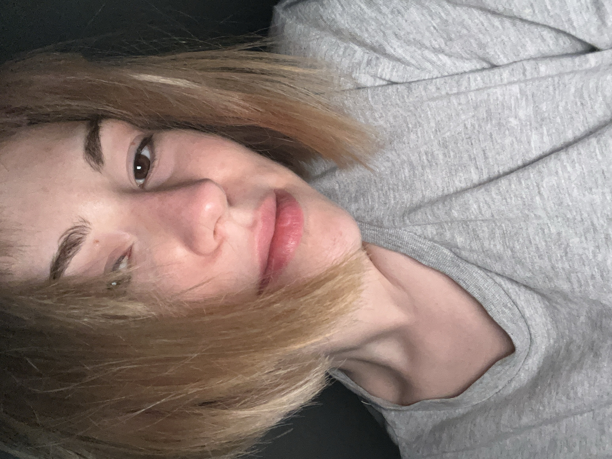 A close-up portrait of a light-skinned woman with brown eyes and blonde hair. She is wearing a gray shirt. There is no indication in the image that the subject is in Boreti, Montenegro.