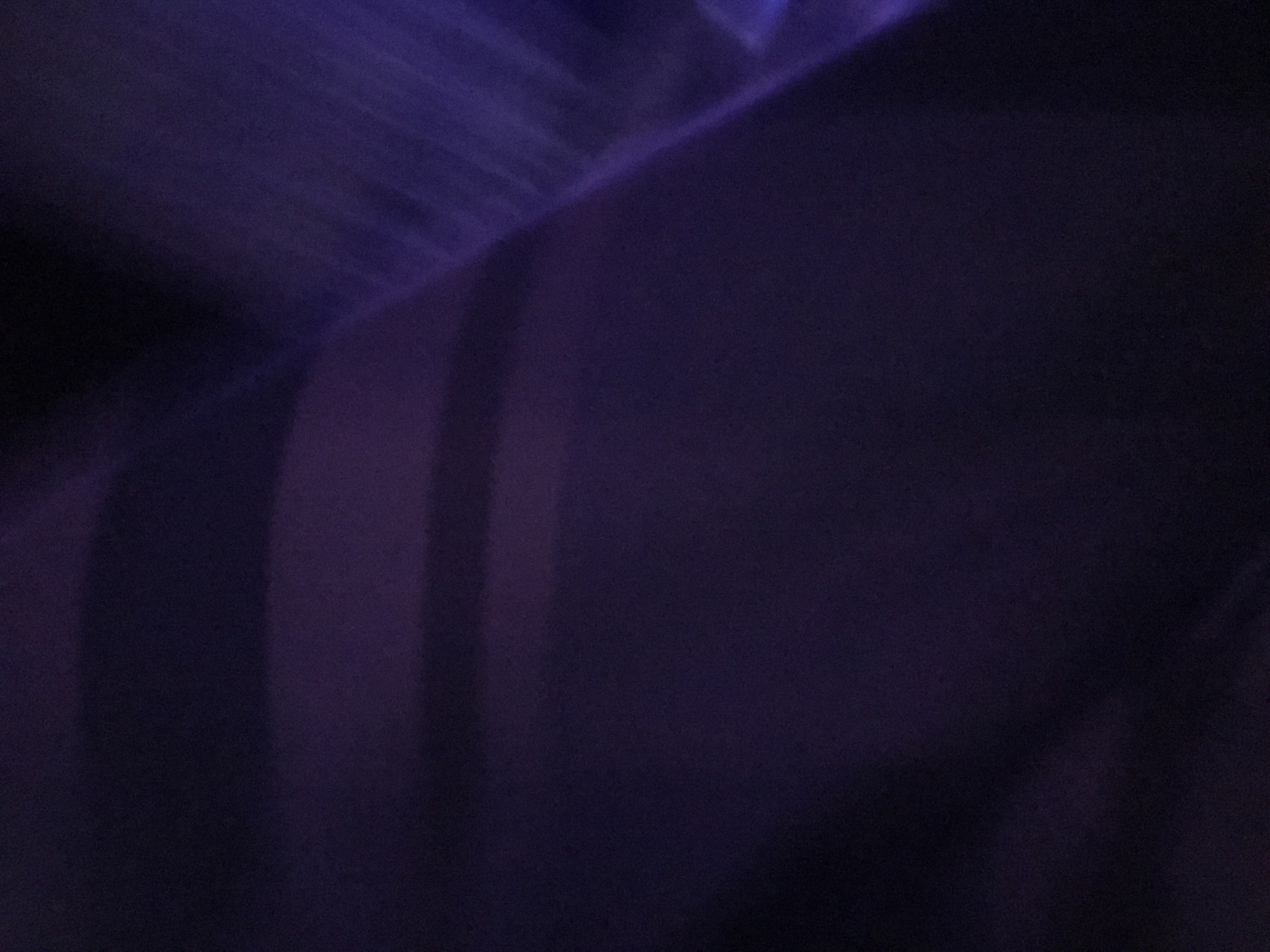 The image is a dark, blurred photograph, predominantly purple in hue. There are vague, indistinct shapes that suggest a possible structure or fabric, and bands of lighter purple that might be light reflections or shadows. The location in Yerevan, Armenia cannot be determined from the image. There are no people, actions, or interactions visible.