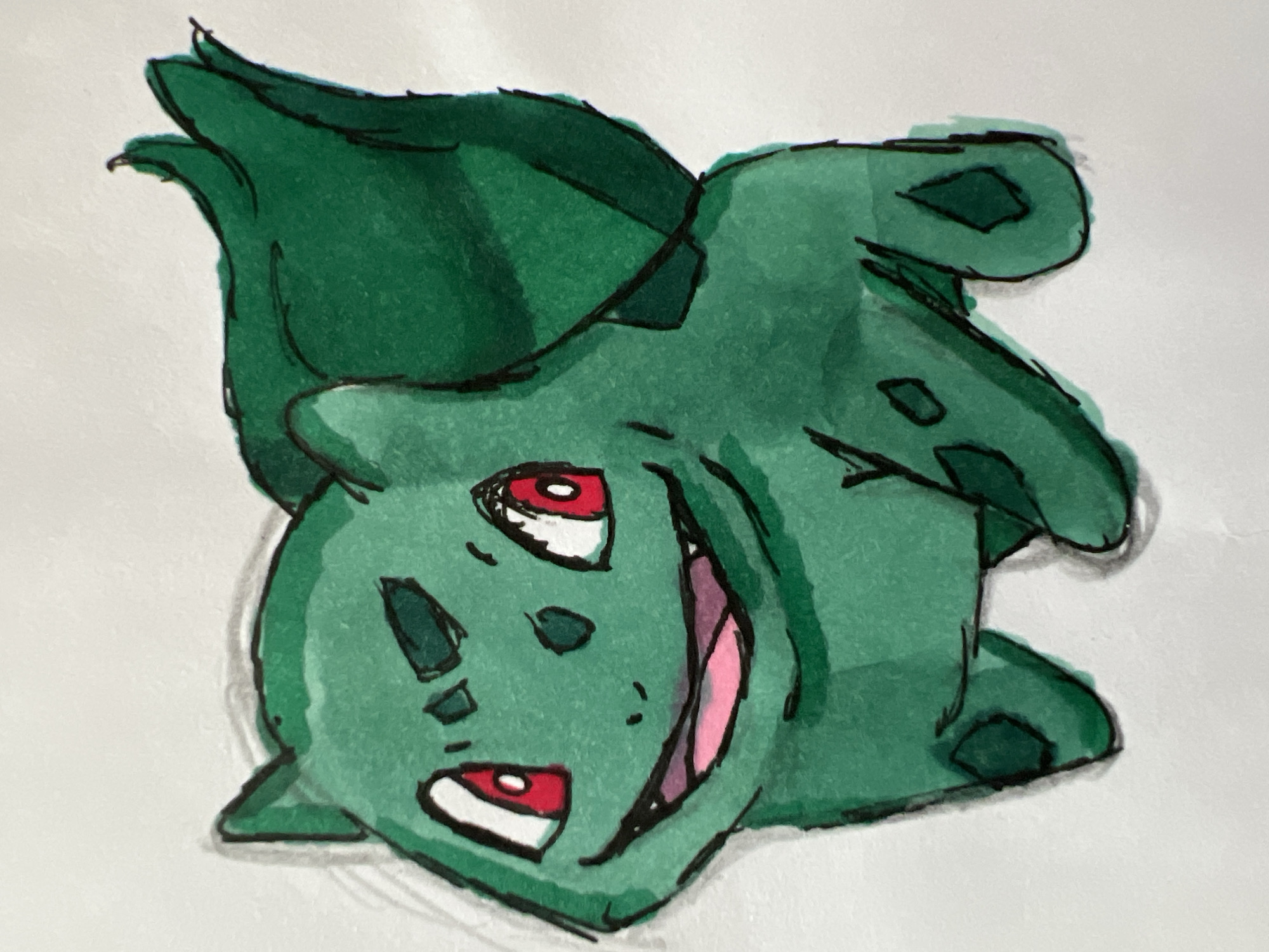 This is a watercolor and ink drawing of Bulbasaur, a fictional creature from the Pokémon franchise. The drawing is rendered in a playful, cartoonish style. Bulbasaur is depicted upside down, with its large bulbous plant growth on its back forming the top of the image. Its green skin is colored with varying shades of green watercolor, and the outlines are drawn with black ink. Bulbasaur has large, round red eyes with white pupils and black irises, a wide grin showing pink gums and purple on the inside of its mouth, and small, dark green diamond shapes scattered across its body, which are characteristic features of the creature. The background is a plain white surface. The drawing appears to be a piece of fan art or a personal artistic creation. There is no discernible text within the image. The scene is a close-up of the illustrated creature, with no indication of a specific time of day, weather, or location. The overall emotion conveyed is one of mischievous excitement due to its wide open mouth and bright eyes.