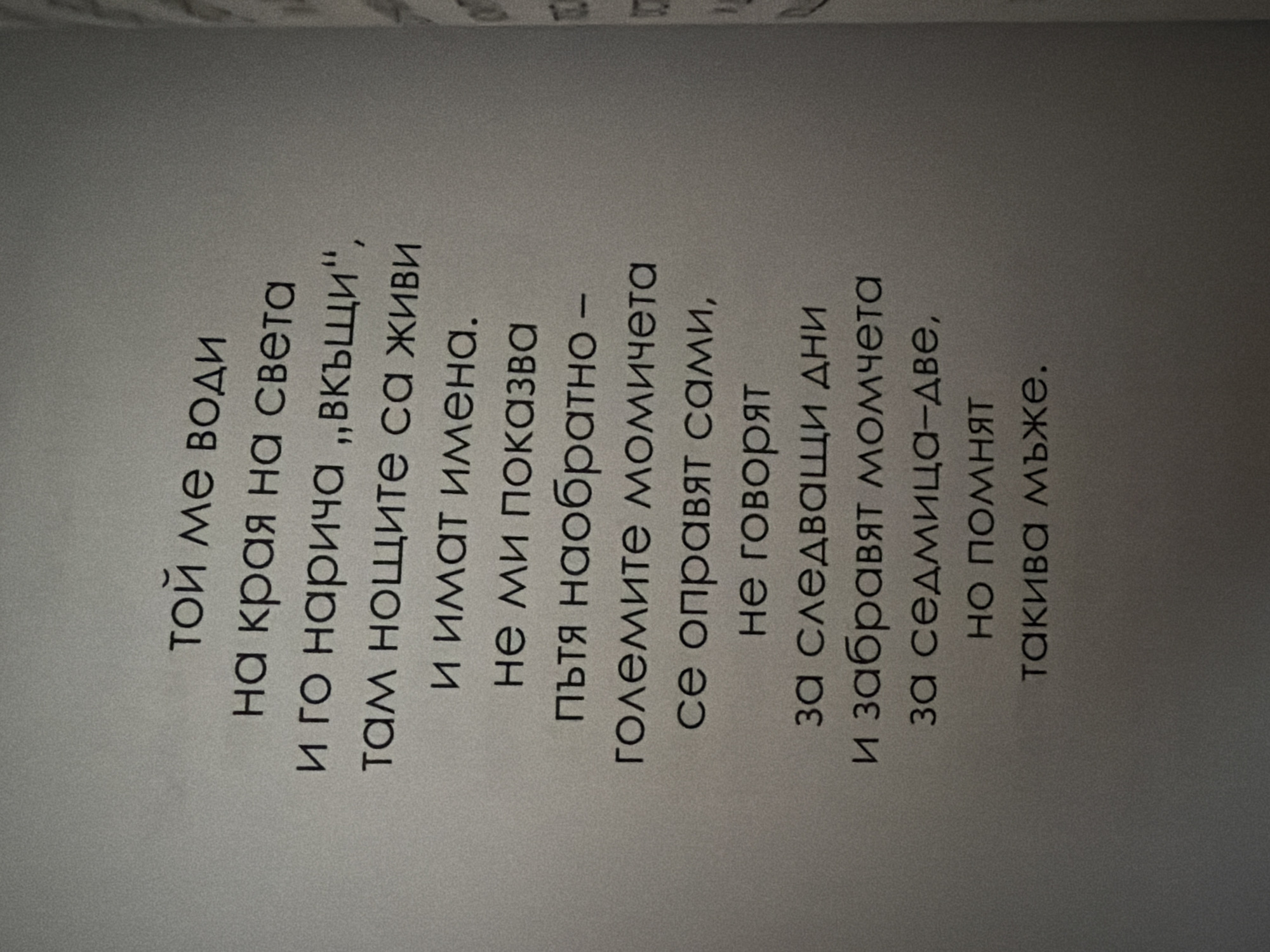 The image contains text in Bulgarian, arranged in lines. The text appears to be a poem or prose. The text is centered on a gray background that is slightly textured, suggesting it is a page from a book or document. There are no discernible people, subjects, objects, actions, interactions, or environmental details beyond the text and its background. The location of Pazardzhik, Bulgaria is not depicted or referenced in the image.