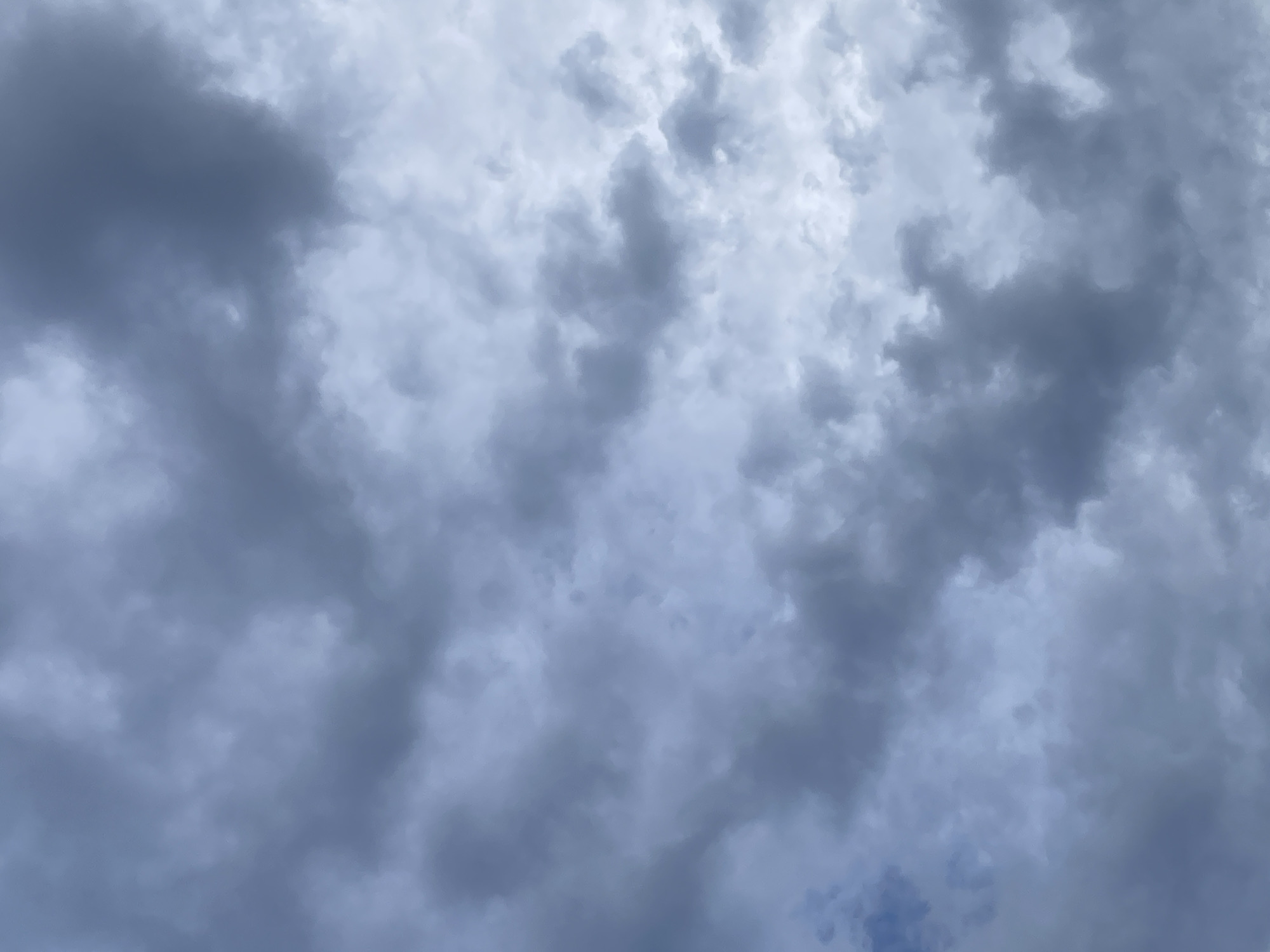 The image shows a sky filled with dark, ominous clouds. The clouds are various shades of gray and appear dense, possibly indicating an approaching storm. The sky is the dominant feature of the image, occupying the entire frame. There is no ground, horizon, or any other discernible objects in the scene. The location is unknown.