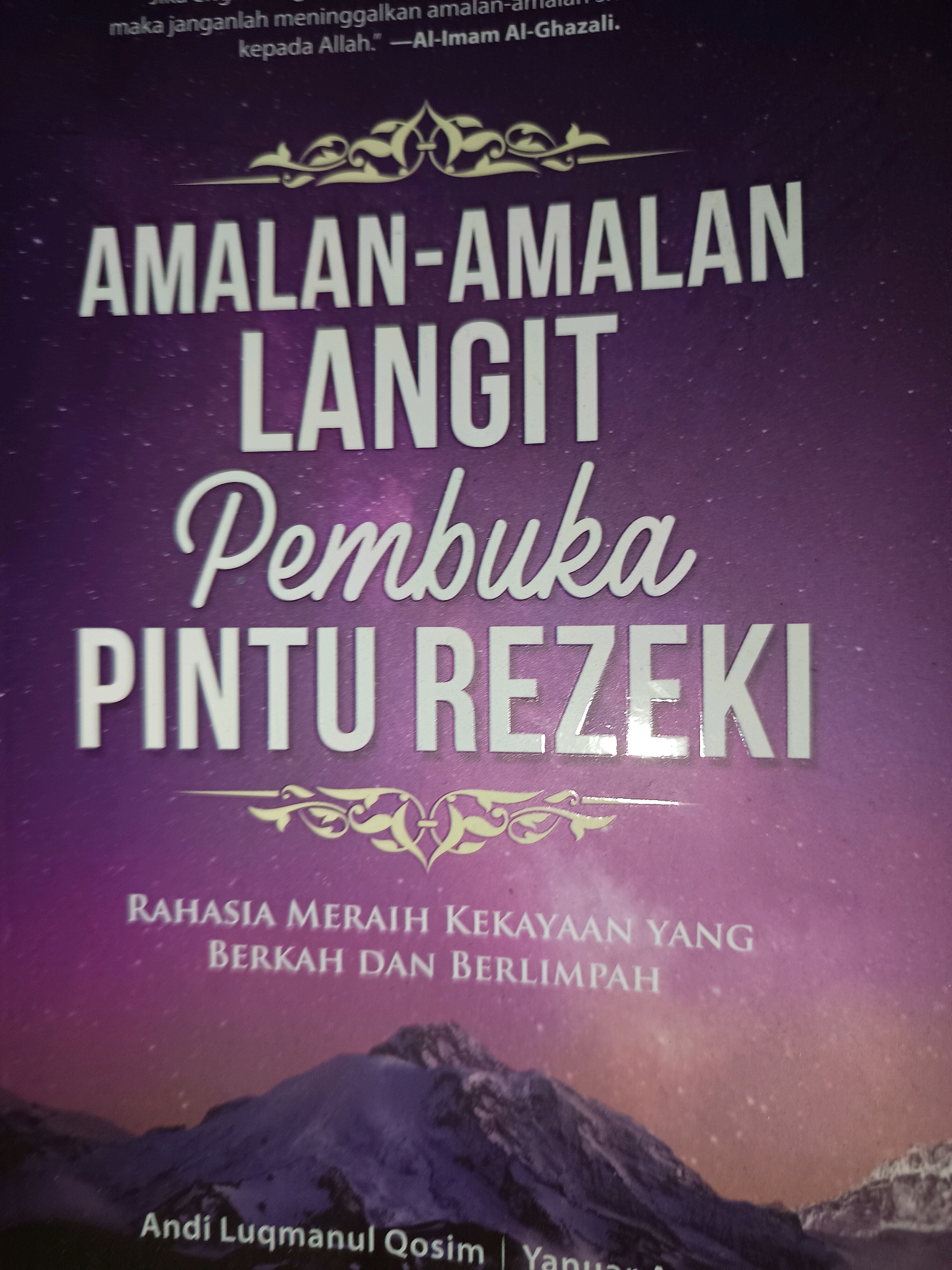The image shows the cover of a book with a purple, star-filled background and a snowy mountain range at the bottom. The title of the book is written in large white letters. The main title reads "AMALAN-AMALAN LANGIT PEMBUKA PINTU REZEKI". Below this, in smaller text, it says "RAHASIA MERAIH KEKAYAAN YANG BERKAH DAN BERLIMPAH". At the very bottom of the cover, the author's name is visible: "Andi Luqmanul Qosim". There are no people or actions depicted in the image. The image is not specific to any city in Indonesia, including Gunung Sekar.