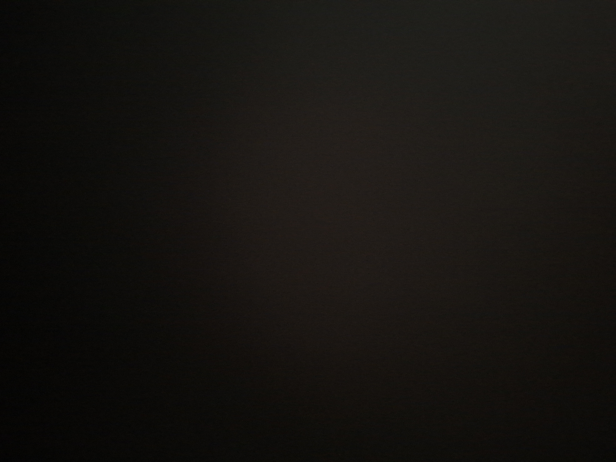 The image displays an almost entirely black field, with no discernible subjects such as people or clear objects. No specific activity or event is taking place. The scene is characterized by its extreme darkness, which prevents any determination of the time of day, weather conditions, or specific location cues, including any connection to Sofia, Bulgaria. A very subtle, fine-grained texture is visible across the dark surface, suggesting it may be a photograph of a uniformly dark material or an extremely underexposed environment. No text is visible.