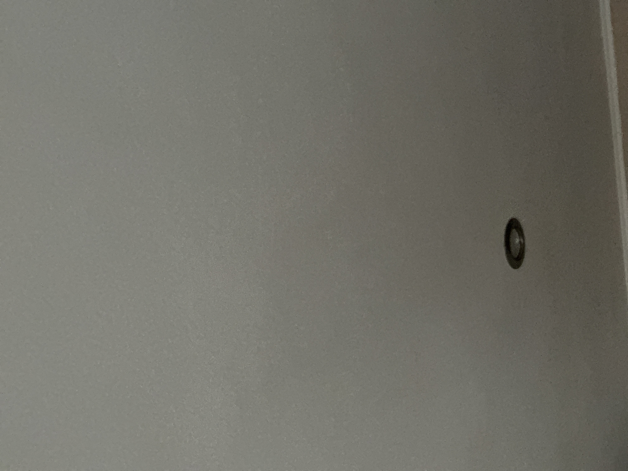 The image shows a light gray wall with a small, circular, recessed light fixture on the right side. The wall appears to be plaster or drywall with a slightly textured surface. The location in Lovech, Bulgaria is not discernible from this image.