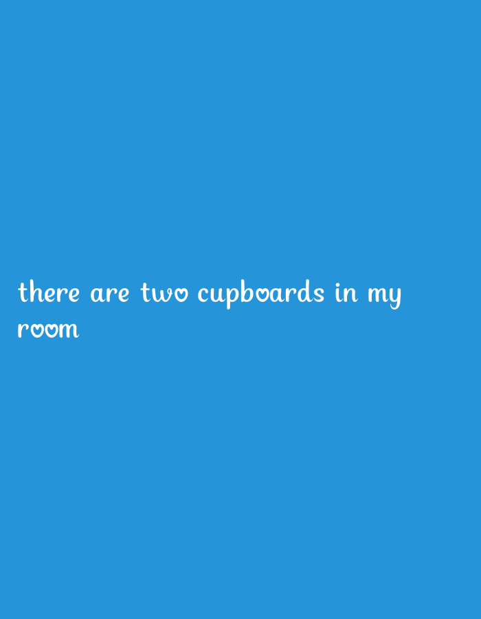 A white text overlay on a solid blue background reads "there are two cupboards in my room". Two heart symbols are used in place of the letter "o" in "two" and "room".