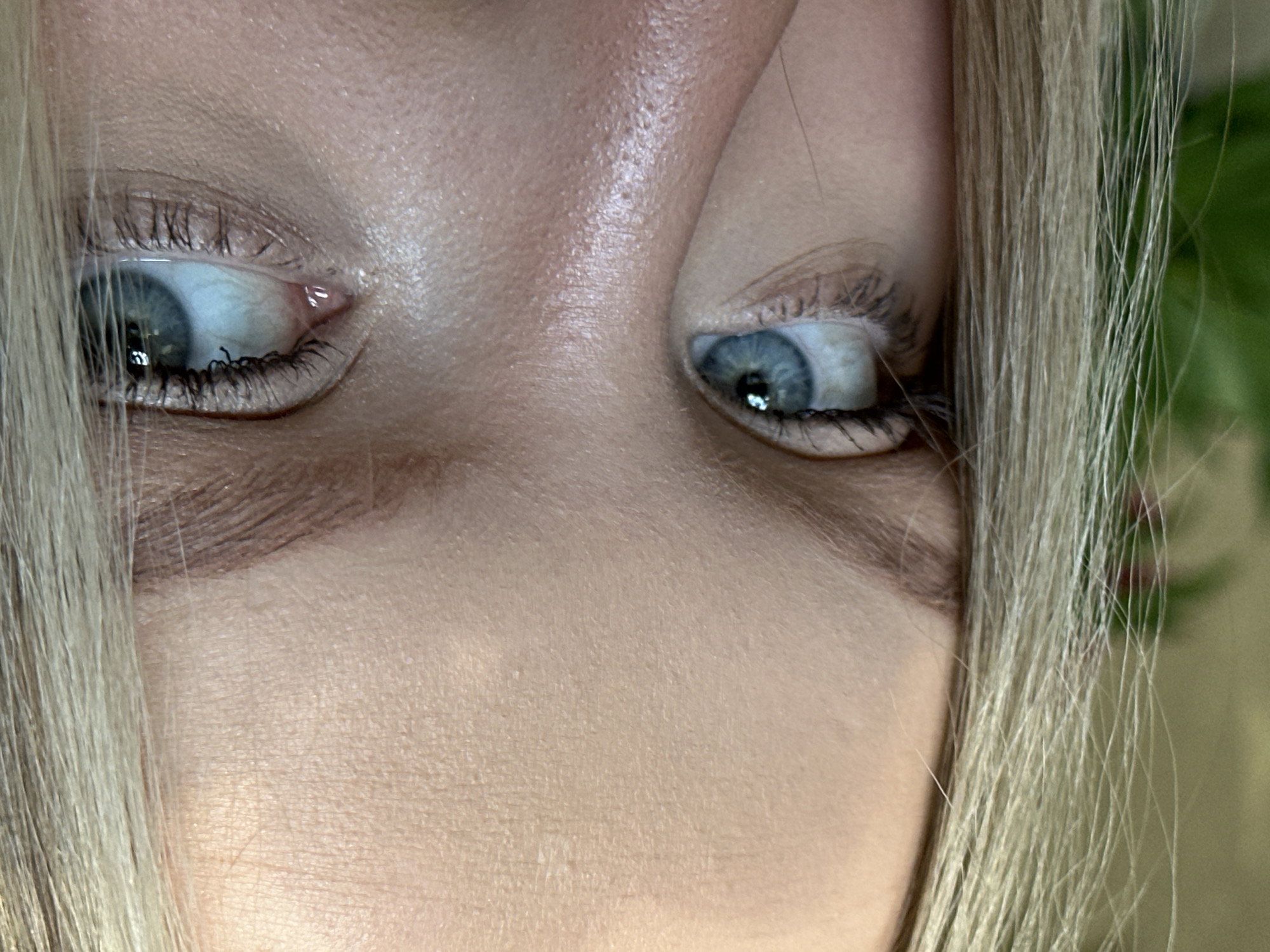 This is a close-up photograph focusing on a person's eyes and surrounding facial features. The person has light skin, blue eyes, and blond hair that frames their face. The eyes appear to be looking slightly upwards and to the side. The image captures details of the skin texture, eyelashes, and the irises of the eyes. There is no discernible context indicating the location of Chaikovsky, Russia.