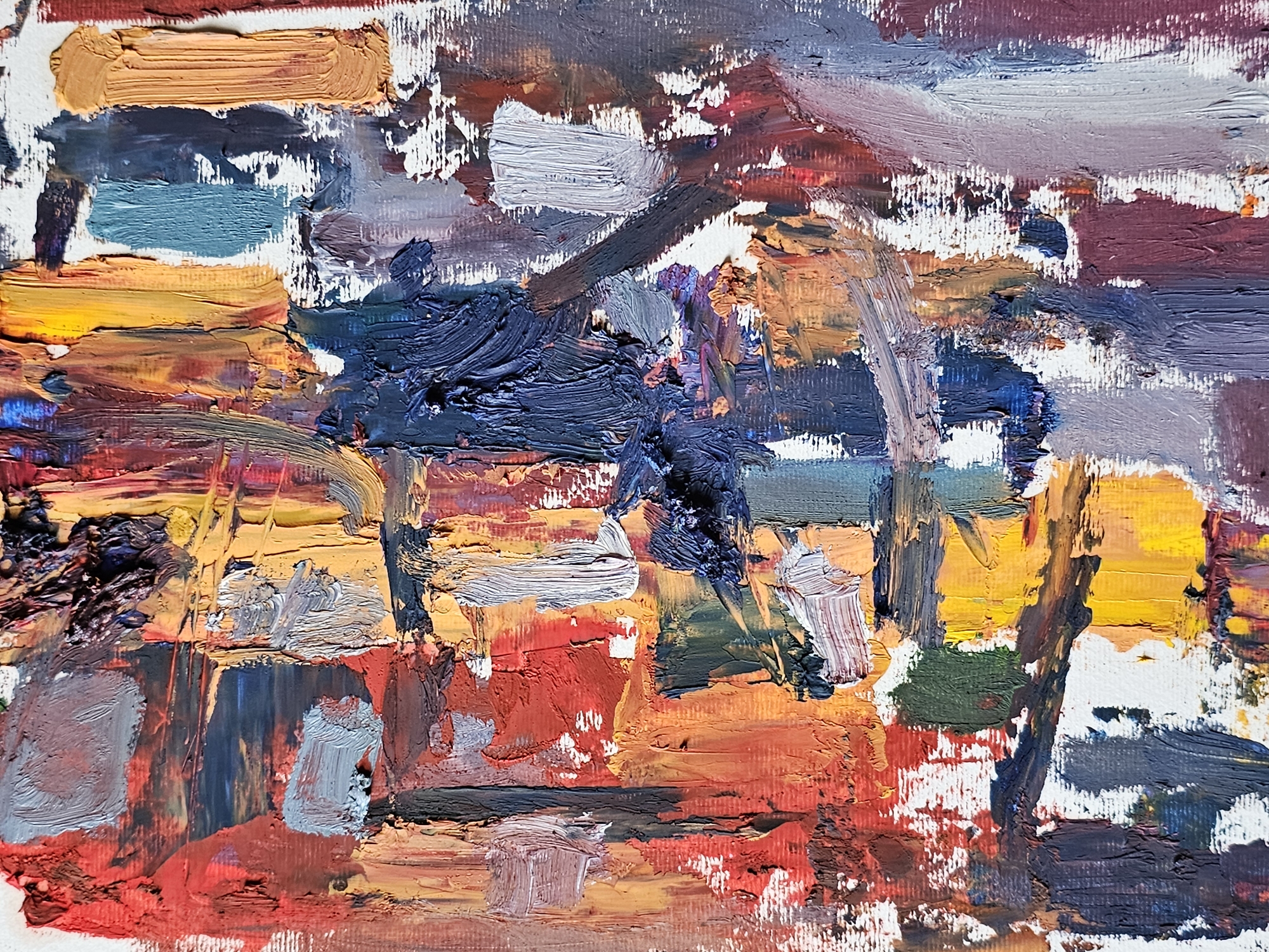 The image is an abstract oil painting of a cityscape, strongly suggested to be the city of Plovdiv, Bulgaria. The city is rendered in thick, impressionistic strokes of color, including hues of red, orange, yellow, blue, gray, white, and purple. There are no discernible figures or people. Objects are abstracted, but vaguely suggest building structures. The overall environment is urban and impressionistic, conveyed through the bold application of paint and the layering of colors.
