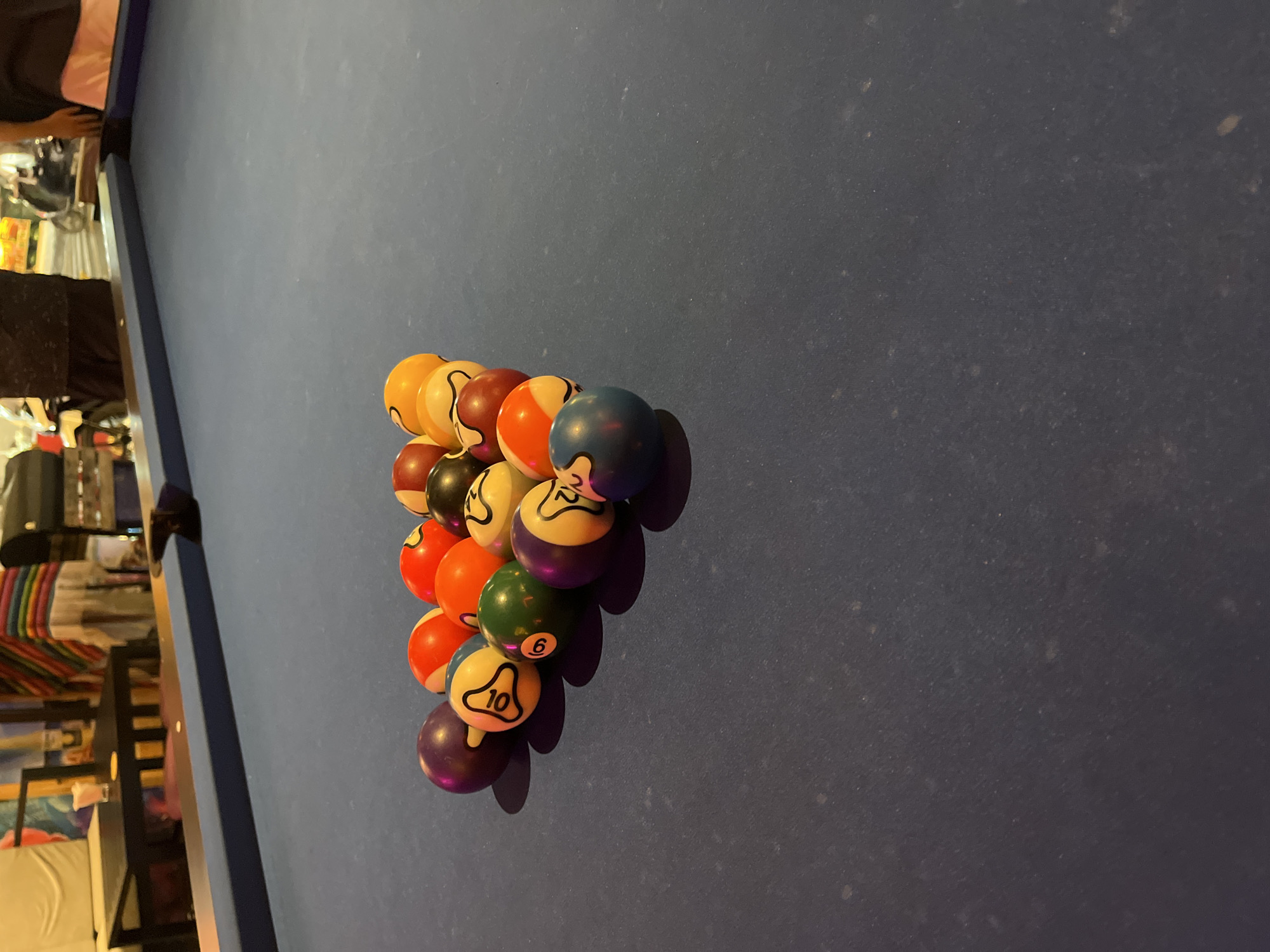 The image shows a racked set of pool balls on a blue pool table. The balls are arranged in a triangular formation. The table has a blue felt surface. The image was taken in the city of Đà Nẵng, Vietnam.