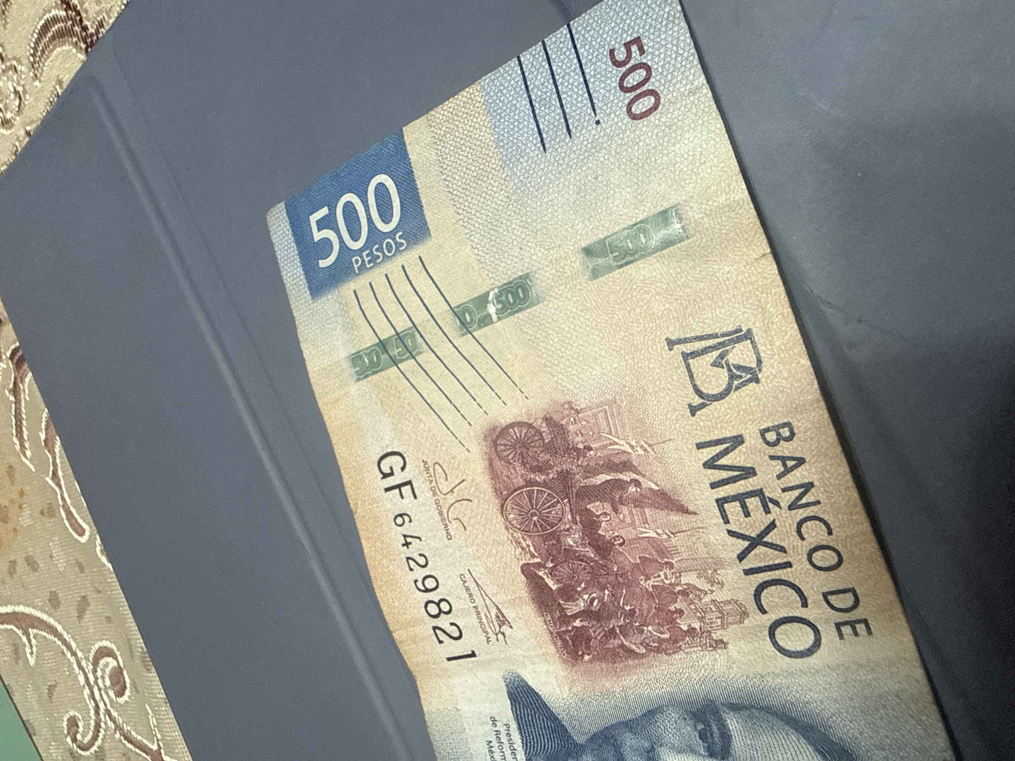 The image shows a 500 Mexican peso banknote resting on a gray surface. The blue section displaying the number "500" and "PESOS" is visible. The text "BANCO DE MEXICO" is vertically oriented on the note. The serial number "GF6429821" is printed on the bill. The image does not give any indication of it being located in San Cristóbal, Mexico.