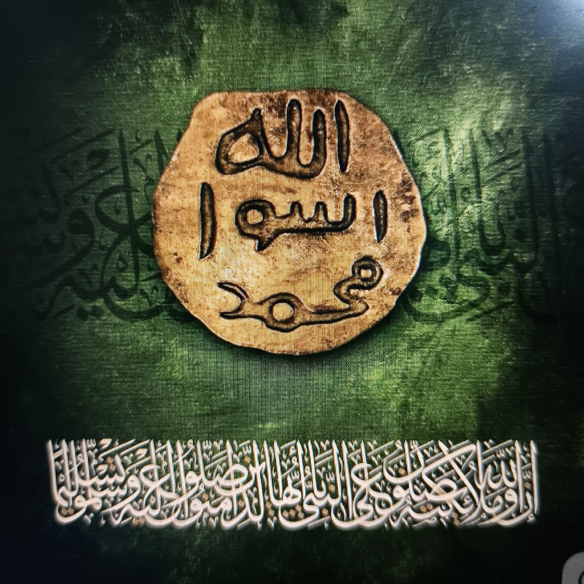 The image is a digitally rendered artwork featuring Islamic calligraphy on a textured green background. The central element is a simulated ancient gold coin with Arabic inscriptions. The coin is oval-shaped and bears two lines of text. The top line appears to read "الله" (Allah), and the bottom line appears to read "محمد رسول" (Muhammad the Messenger). Surrounding the coin, on the green background, are shadowy Arabic script designs. Below the coin, spanning the lower portion of the image, is a larger band of white Arabic calligraphy with a subtle 3D effect, appearing to be raised from the background. The overall composition evokes a sense of religious and historical significance. There is no identifiable location within the city of Poonch, India, in this image; it is a purely artistic representation.