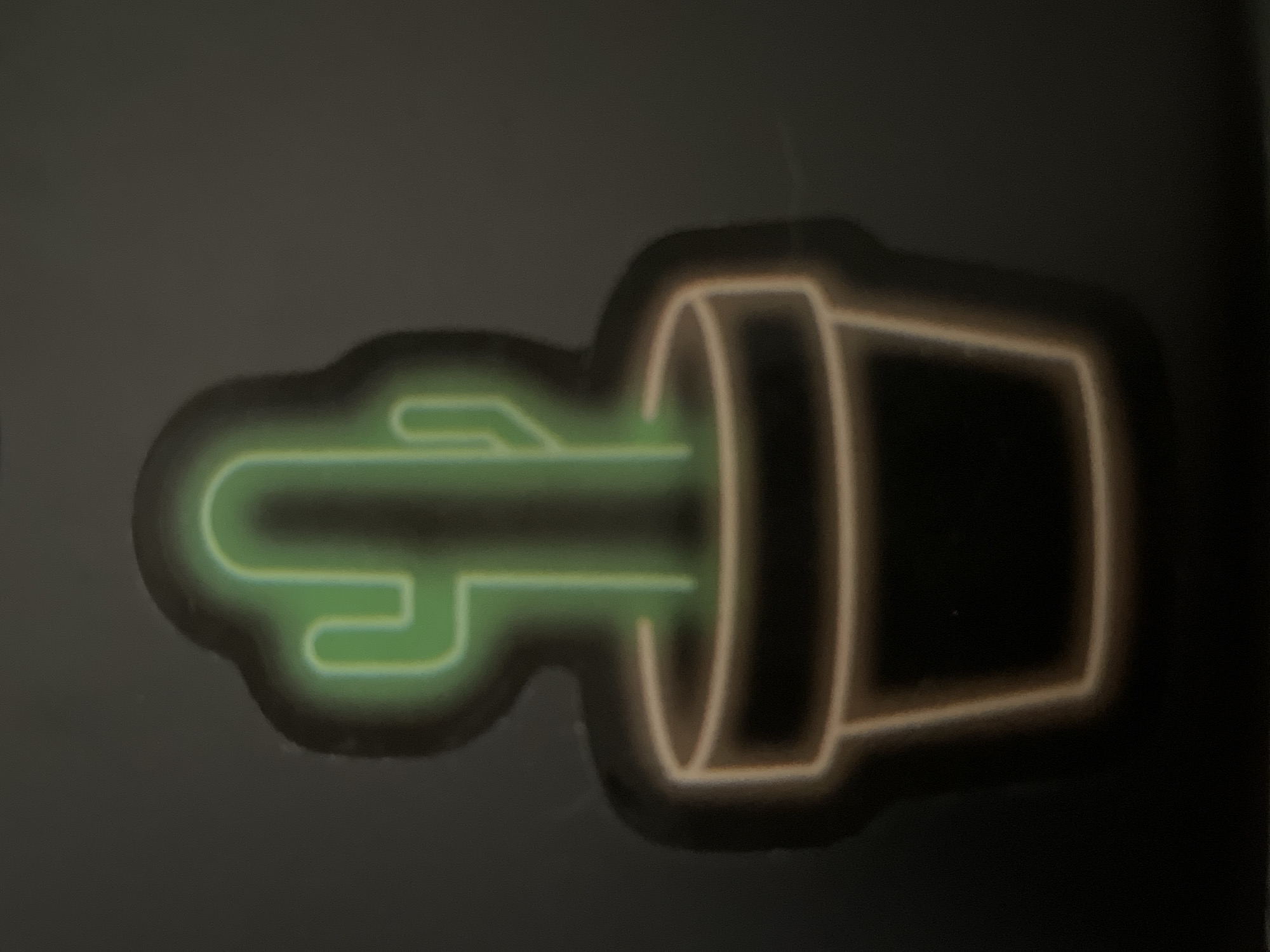 The image depicts a horizontal neon-style image of a cactus in a pot. The cactus is green with a rounded shape, while the pot is tan-colored. The entire image is on a dark, neutral-toned surface. There are no people or other objects visible. The specific location is not evident from the image and cannot be determined to be Novi Sad, Serbia.