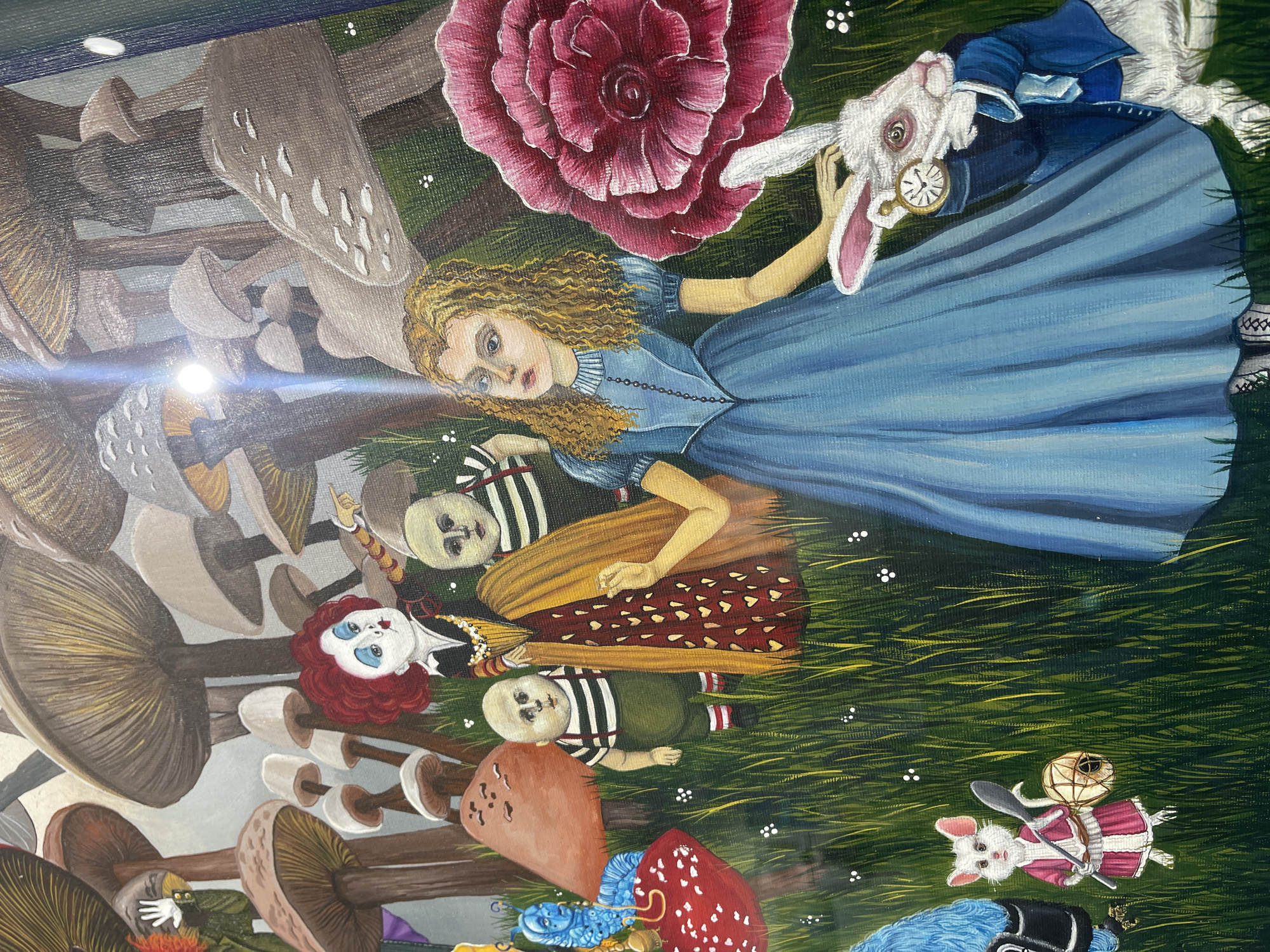 The image depicts an "Alice in Wonderland" themed painting. Alice, with blonde curly hair and a blue dress, is holding the White Rabbit, who is wearing a blue coat and carrying a pocket watch. Nearby are red and grey mushrooms, Tweedledee and Tweedledum. A giant red rose is also present. In the background, there are more mushrooms, grass, and other creatures from the Alice in Wonderland story. There is no information to discern the city of Sofia, Bulgaria, from this image.