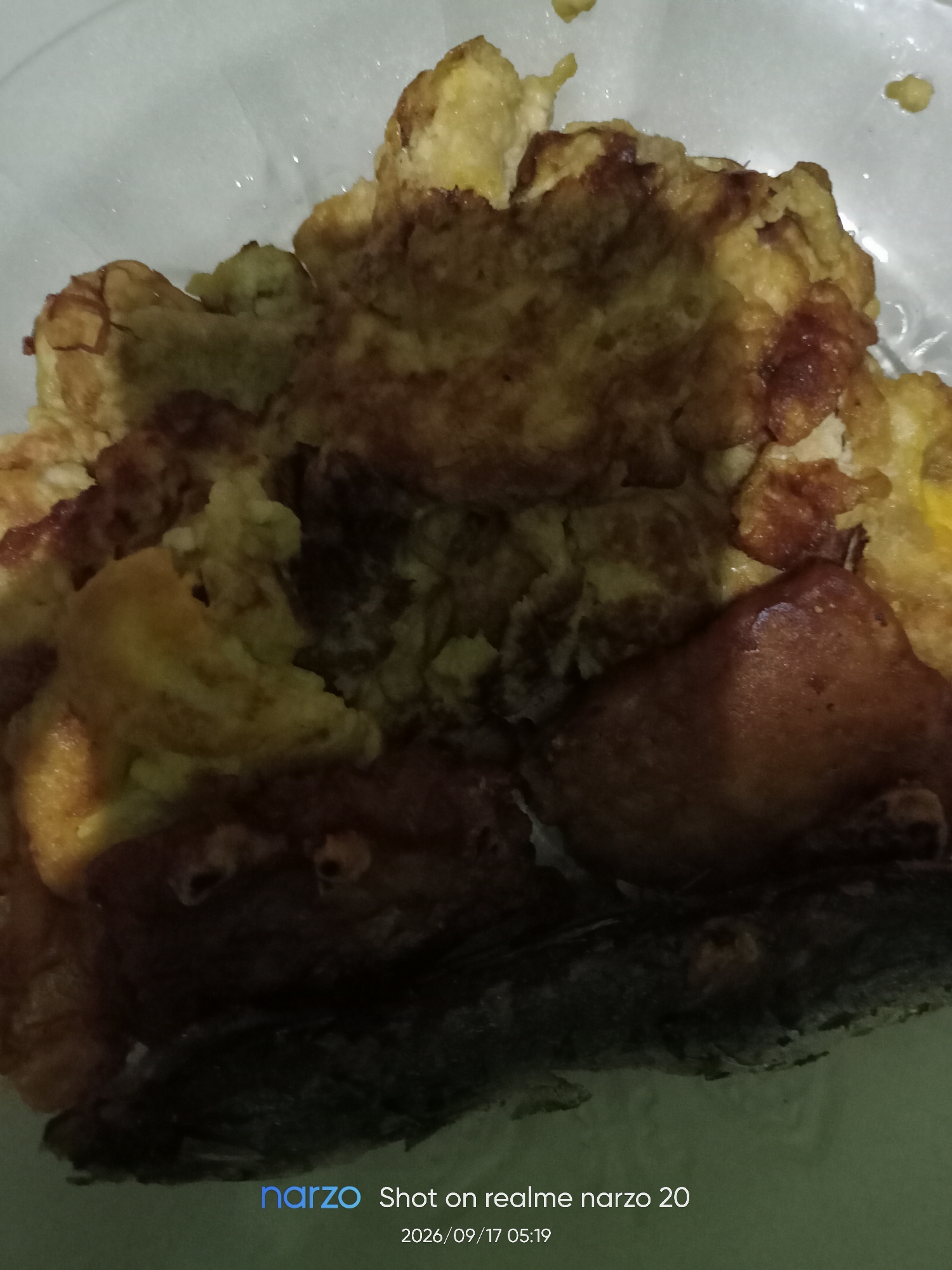 The image shows a close-up of a plate of food, likely an omelet or scrambled eggs with some fried fish. The food is golden brown and appears to be cooked. The background is a light-colored surface, possibly a table or counter. There are no people or specific environmental details visible that would indicate the location within Karawang, Indonesia. The bottom of the image contains a watermark that reads "narzo Shot on realme narzo 20 2026/09/17 05:19".