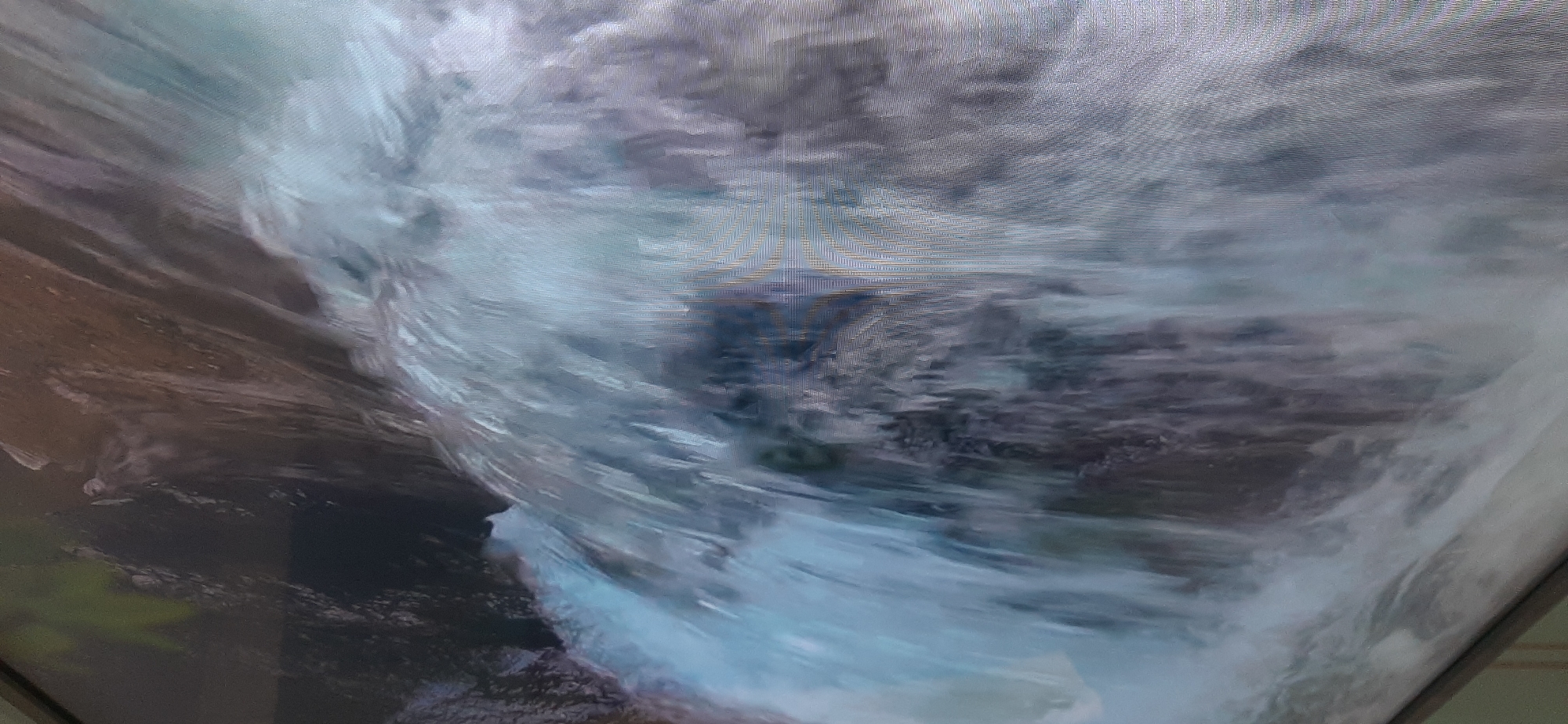 The image shows a close-up, motion-blurred view of a waterfall. The water is white and foamy as it cascades over dark, textured rocks. The lighting suggests it is daytime, and the overall impression is one of natural movement and power. There is no visible indication of the city of Balashikha, Russia, or any specific geographical features that would place it there. The image does not contain any people or identifiable objects.