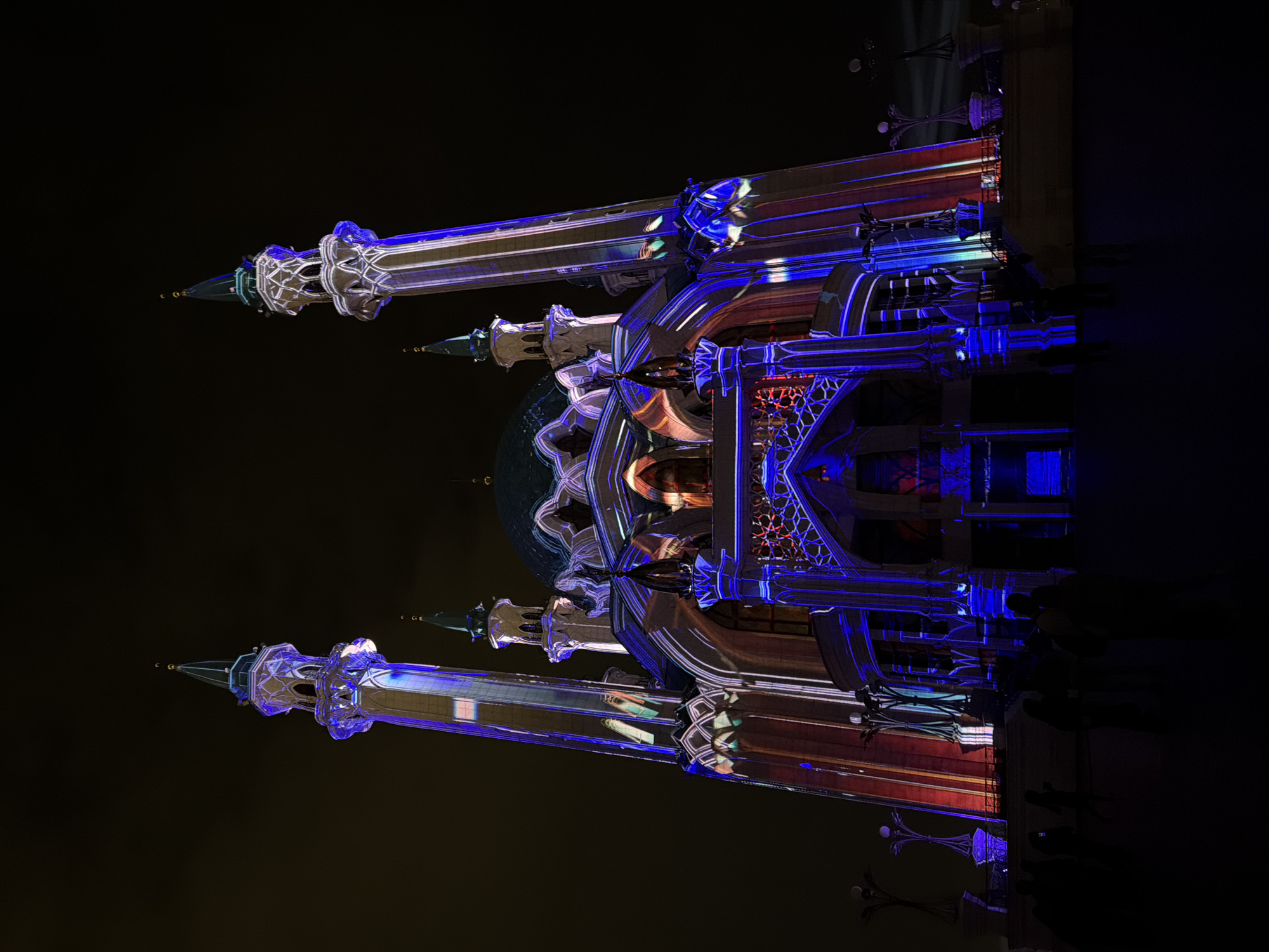 The image showcases the Kul Sharif Mosque in Kazan, Russia, illuminated at night. The mosque's features, including its minarets and dome, are accentuated with blue, purple, and red lighting. The dark night sky provides a contrasting backdrop, emphasizing the architectural details and colorful illumination of the mosque.