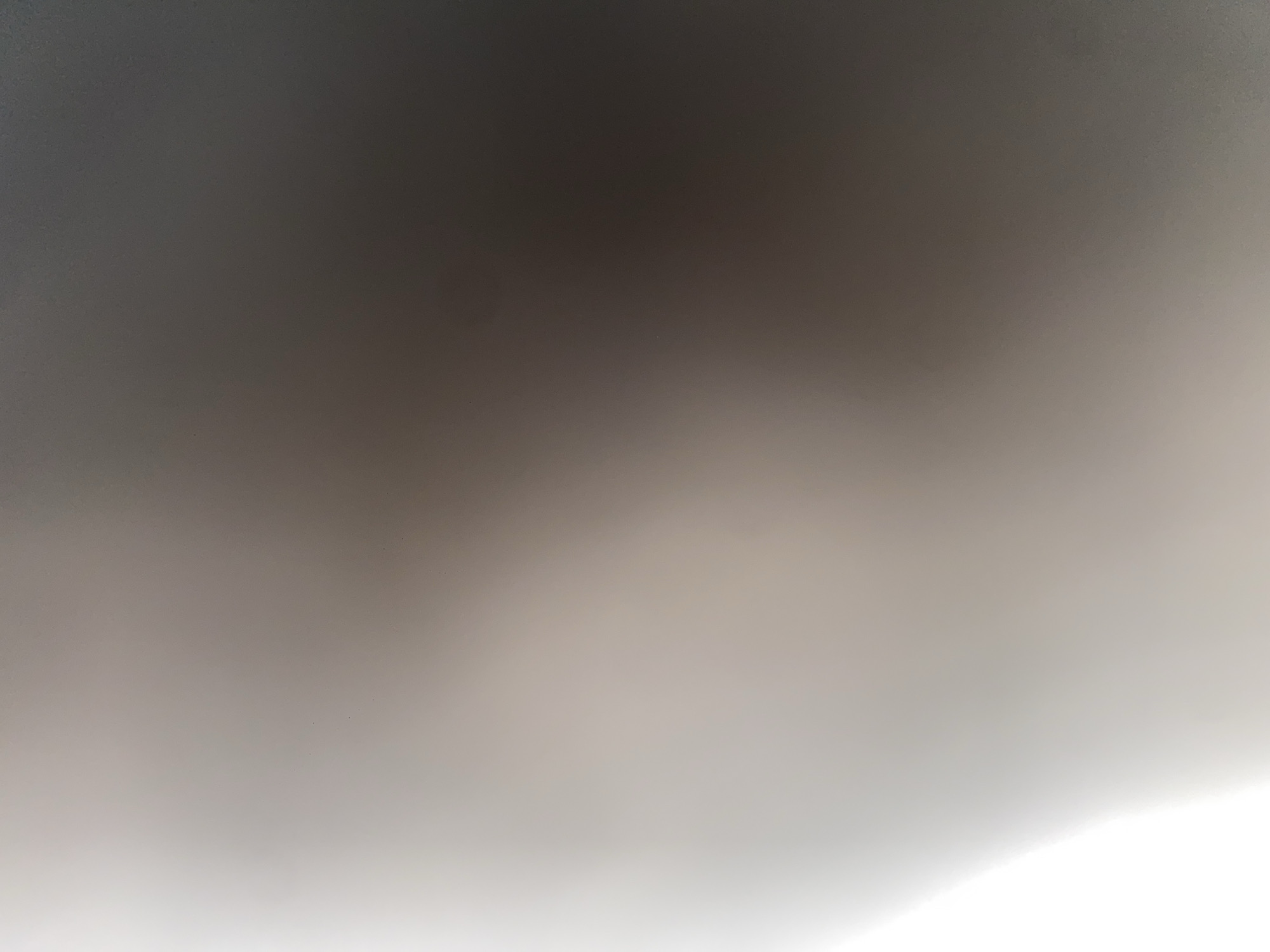 This image depicts an abstract or out-of-focus scene, characterized by a gradient of light and shadow. The left side of the image is bright white, suggesting a strong light source or reflection, and this brightness gradually transitions into darker shades of grey and brown towards the right side. There are no discernible objects, people, or specific environmental features visible that would allow for a detailed description of a scene in Ablanitsa, Bulgaria, or any other location. The image is entirely abstract in nature.