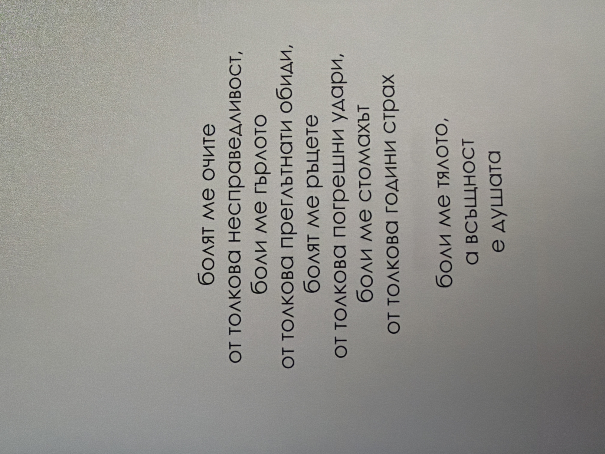 The image displays a poem written in Bulgarian text, centered on a plain, light gray background. The text is printed in a dark, sans-serif font. The poem is composed of several lines, arranged in stanzas, and appears to be a personal reflection or expression of emotions. There are no people, objects, or environmental elements depicted in the image beyond the text itself. The background suggests a simple printed document or a digital display. The provided context of the location in Pazardzhik, Bulgaria, is not visually evident in the image.
