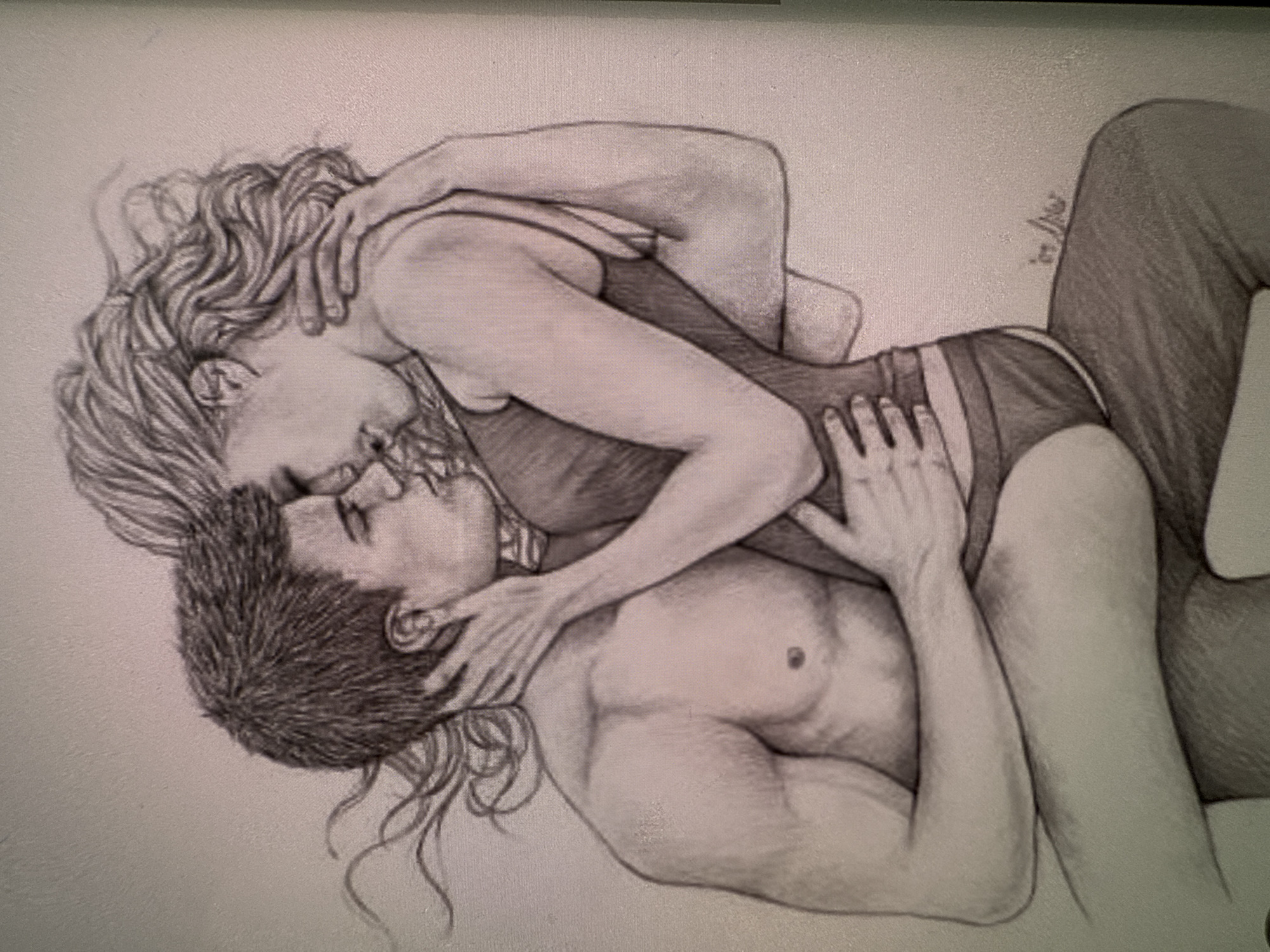 This is a black and white pencil sketch of two people in an intimate embrace. The subjects are positioned in a way that suggests they are lying down, with the woman on top of the man. The woman has long, wavy hair and is wearing a dark-colored, form-fitting outfit, possibly a swimsuit or leotard, with thin straps. Her arms are wrapped around the man's head and neck. The man has short, dark hair and appears to be shirtless, with his arms also around the woman. Their faces are close together, suggesting a kiss or intense emotional connection. The sketch emphasizes the musculature of the man and the curves of the woman.
The overall mood is one of passion and tenderness. There is a small, handwritten signature in the upper right portion of the image that appears to be in script, but the text is illegible. The background is a plain, light surface, providing no context for the setting or time of day. The drawing is detailed, with attention paid to shading and texture, particularly in the hair and skin.