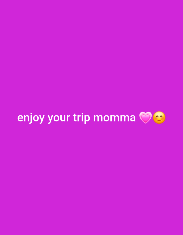 The image is a still from a video featuring a plain purple background with white text that reads "enjoy your trip momma" followed by a pink heart emoji and a smiling face emoji. There are no people, objects, or environmental details present that can be used to determine its location in Egbagu, Nigeria.
