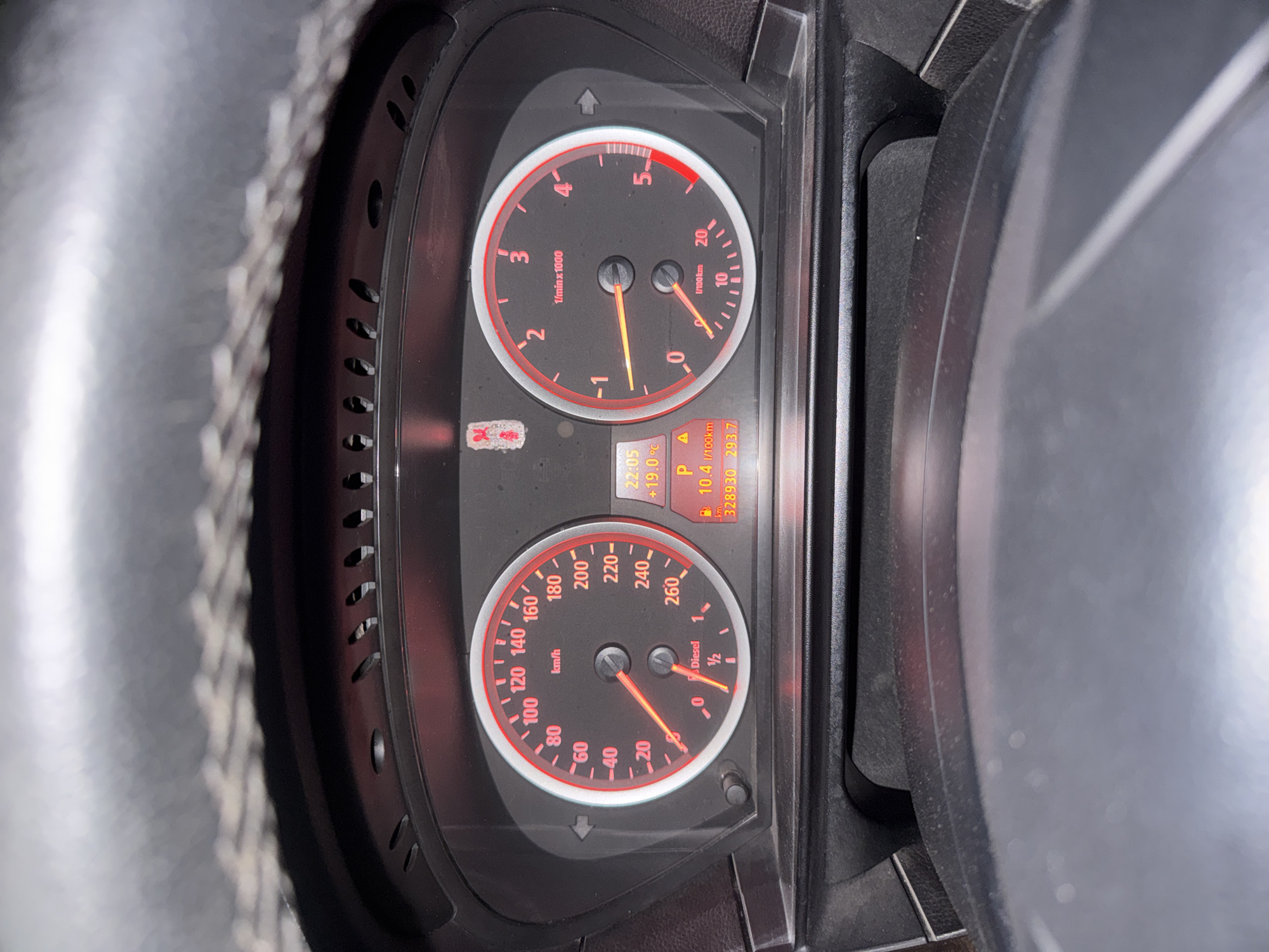The image shows the dashboard of a vehicle. The tachometer indicates an engine speed slightly above 1000 RPM. The speedometer shows a speed of approximately 10 km/h. The fuel gauge reads around half full. The odometer displays a reading of 328930 km, with a trip meter reading of 293.7 km. The display also shows a time of 22:05 and a temperature of 19.0°C. The location is likely Stara Zagora, Bulgaria, based on the common use of kilometers as a unit of measurement.