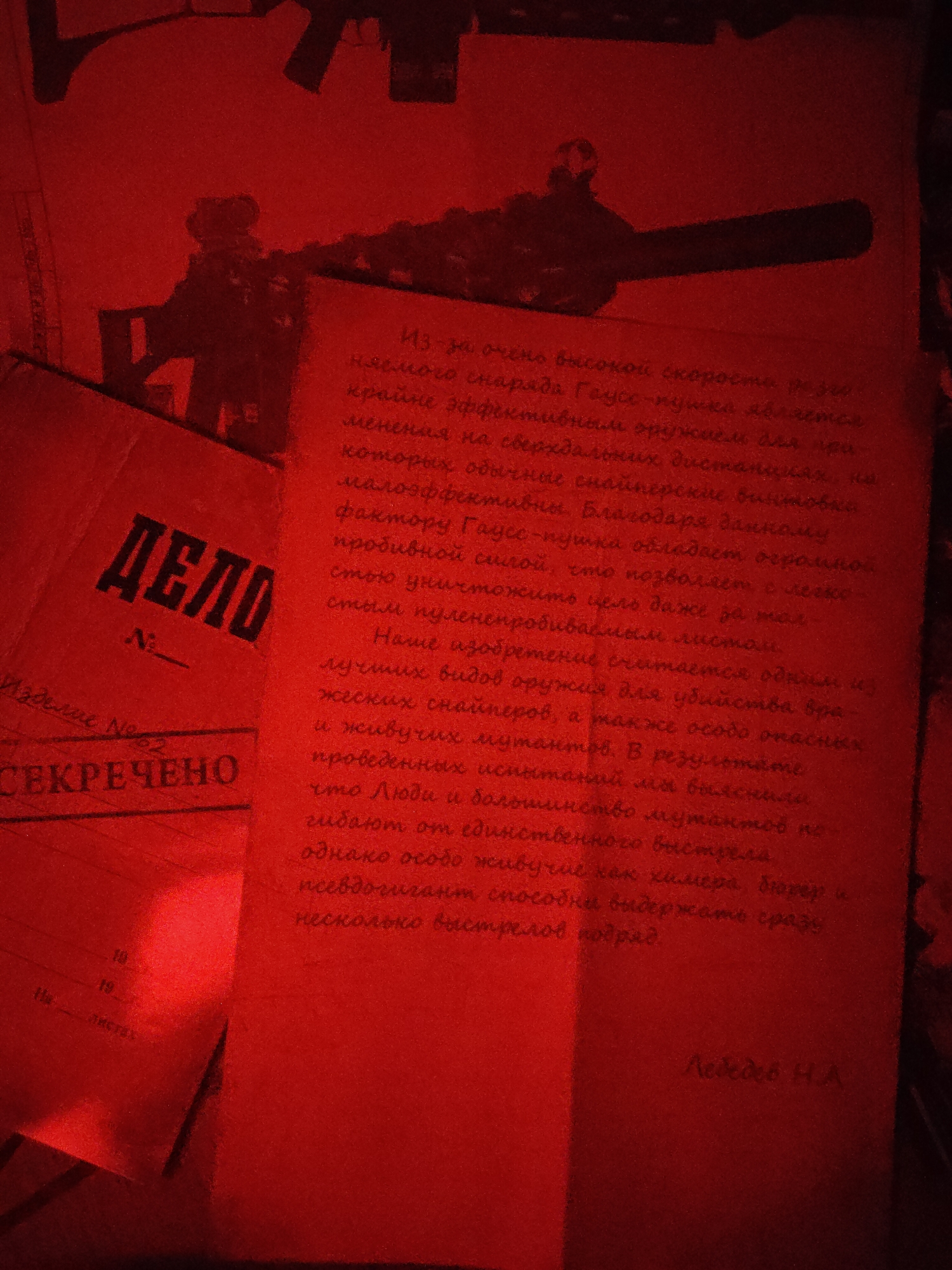 The image shows a red-tinted document, likely a photograph of a dossier or report labeled "ДЕЛO" (Case) in Cyrillic script. The document has the stamp "СЕКРЕЧЕНО" (Secret) and the designation "Изделие No. 22" (Product No. 22) suggesting a classified status. The text on the document appears to describe a "Гаусс-пушка" (Gauss rifle), praising its effectiveness against snipers and mutants due to its high projectile speed and penetration power. It notes that most targets die from a single shot, but particularly resilient mutants like "химера, бюрер" (chimera, burer) can withstand multiple shots. The document is signed "Лебедев Н.А." (Lebedev N.A.) The location is not mentioned in the document. In the background, blurry outlines of firearms can be discerned. The scene suggests a clandestine or secretive setting involving advanced weapon technology.