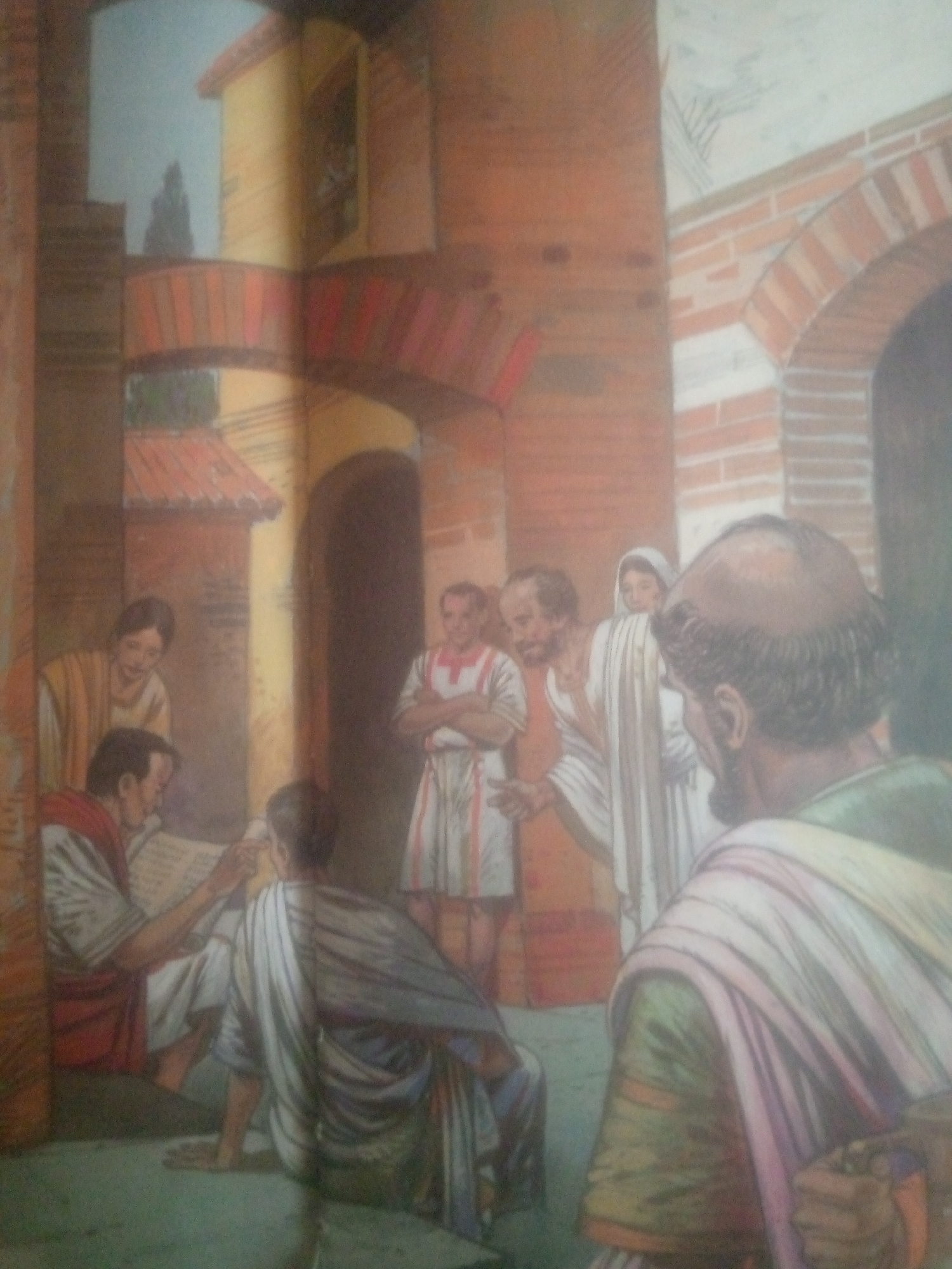 The image depicts an outdoor scene within a historically inspired architectural setting, possibly a courtyard or a public square, characterized by brick arches, stucco walls, and tiled roofs. The style suggests a Roman or ancient Mediterranean influence, not consistent with any known architecture in Jauro Yinu, Nigeria.
Several individuals are present, all dressed in draped robes, consistent with ancient attire. In the foreground, a bald man with a beard, seen from the back, is wearing a green and purple draped garment. To his left, a man seated on the ground, wearing a red and white toga, is engaged in reading a scroll or document. He is interacting with another figure whose head is visible, also seated. Another woman, wearing a yellow and white garment, stands behind the seated man, observing.
Further back, a man in a white and red tunic stands with his arms crossed. Another woman, wearing a hooded white robe, is partially visible behind him. The overall atmosphere suggests a gathering or a moment of instruction or discussion. The environment is rendered with warm, earthy tones, with a clear sky visible in the upper left quadrant. The artistic style is painterly, with soft brushstrokes and a focus on light and shadow to create depth.