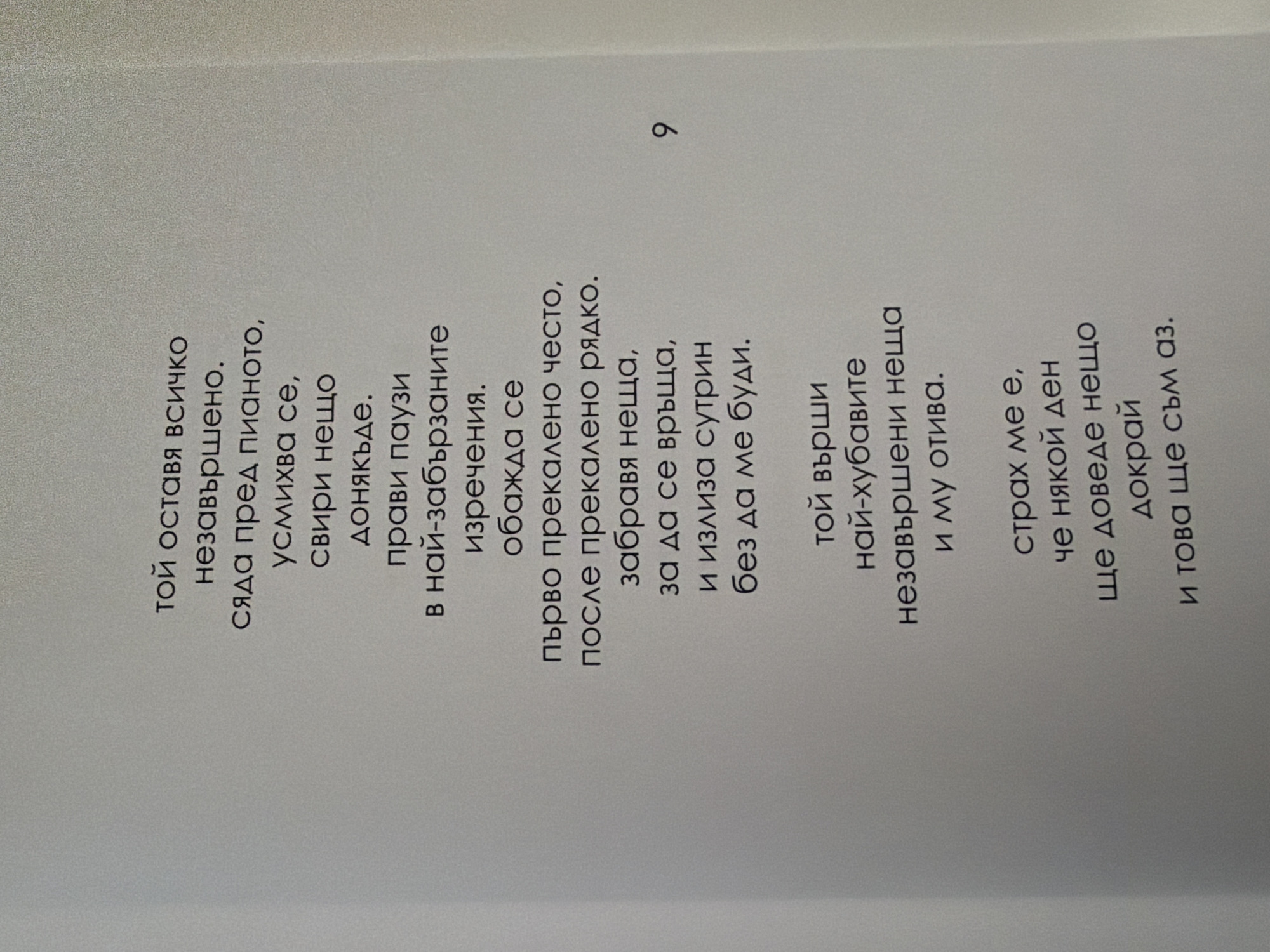 The image is a close-up shot of a page from a book, featuring lines of text in Bulgarian. The text is arranged in stanzas and appears to be poetry or prose. There is a number "9" to the right of the text, likely indicating a page number. The background is a plain, light-colored surface, possibly a wall or a table, with a subtle texture. There are no discernible elements that would allow for the determination of a specific location within Pazardzhik, Bulgaria, or any other city. The image is focused on the textual content of the page.