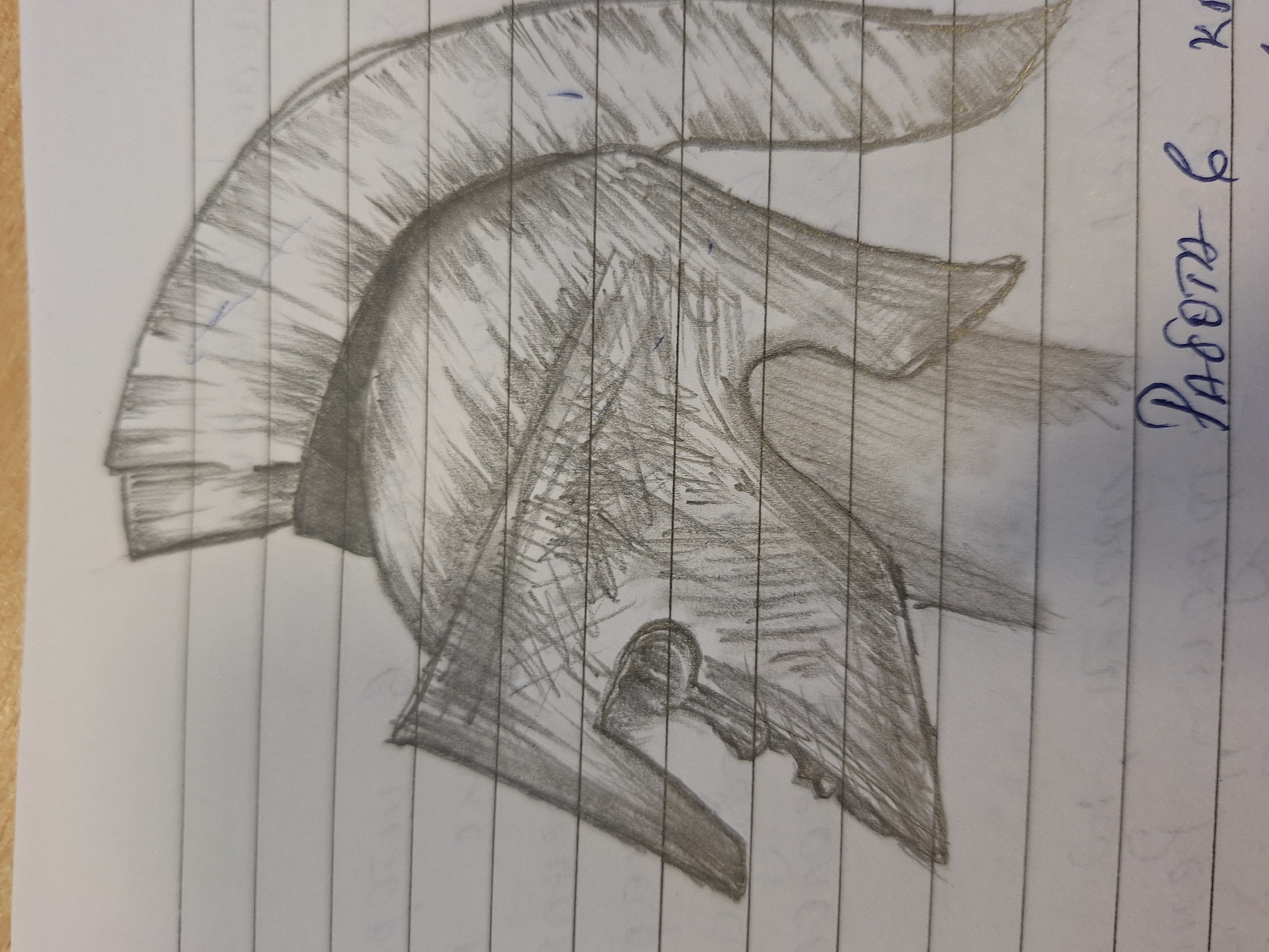 The image is a pencil sketch of a Spartan helmet on lined paper. The helmet is depicted in profile, facing left, with a prominent crest of vertical lines. Shading is used to create depth and texture on the helmet's surface. The drawing is on lined notebook paper, which is visible in the background. In the bottom right corner of the image, there is handwritten text in blue ink, which appears to be in Cyrillic script. The text reads "Работа в" which translates to "Work in". No specific location in Varna, Bulgaria, is depicted or suggested by the drawing.