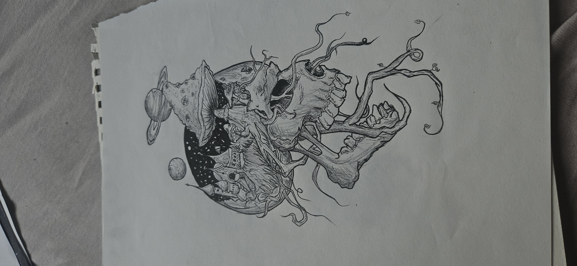 The image is a black and white drawing on a piece of paper with a torn edge. The drawing depicts a surreal scene with elements of space, fantasy, and horror. A circular form, possibly a planet, is partially filled with a starry sky and a fantastical city with spired buildings. The city is located on the lower half of the circle. To the left of the planet are two celestial bodies, one with rings. Emerging from the right side are decaying skulls and skeletal structures intertwined with branching vines. The vines have small leaves attached to them.
I am unable to provide the specific location in the city of Kostenets, Bulgaria, because it is not present in this image.