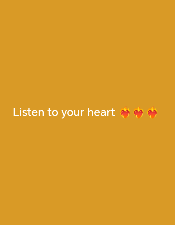 A simple graphic features the text "Listen to your heart" in white lettering centered horizontally and positioned in the lower third of the frame. To the right of the text are three animated heart emojis with flames on top. The background is a solid, warm orange color. No information is available to determine the location in Saratov, Russia.