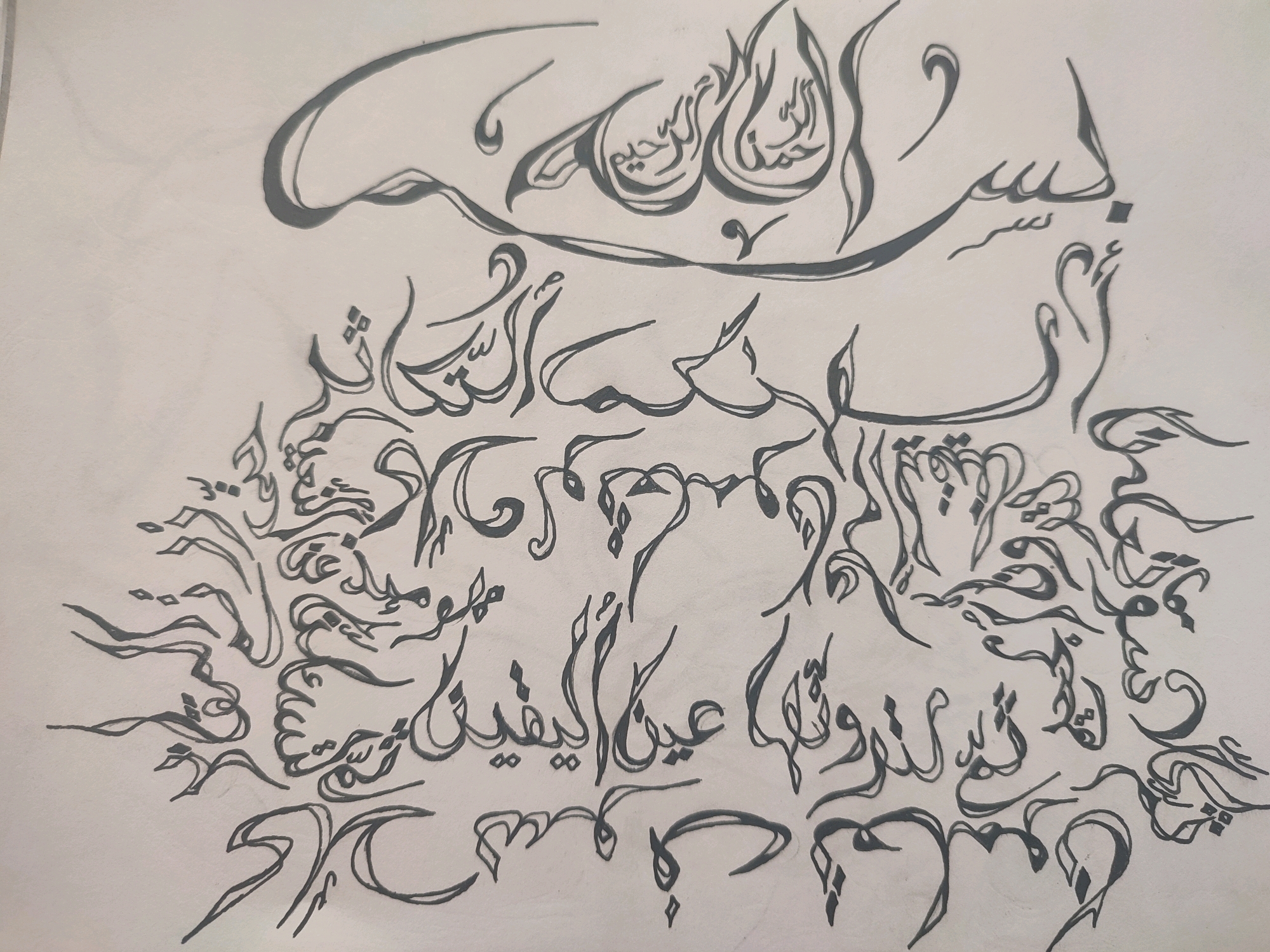 The image is a drawing of Arabic calligraphy on a plain white background. The calligraphy is done in a dark gray ink and features elaborate swirling and flowing lines. The text appears to be a religious phrase, likely from the Quran or a Hadith, given its ornate presentation. There are no people, objects, or environmental elements visible in the image besides the drawing itself. The drawing does not depict any specific location, and therefore cannot be associated with the city of Krasnoye Selo, Russia.