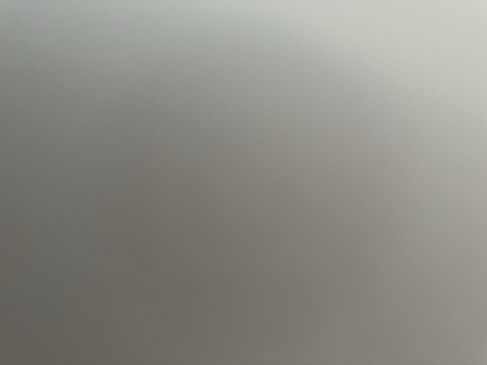 The image is a close-up, out-of-focus photograph of a plain, light-colored surface, possibly a wall or a ceiling. The lighting suggests an indoor environment with a gradient of light from left to right, with the right side being brighter. There are no discernible objects, people, or specific environmental features visible in the image. Without any context or identifiable elements, it is impossible to determine the location, time, or any other details about the scene. Therefore, no information about Belgrade, Serbia, or any specific details can be extracted from this image.