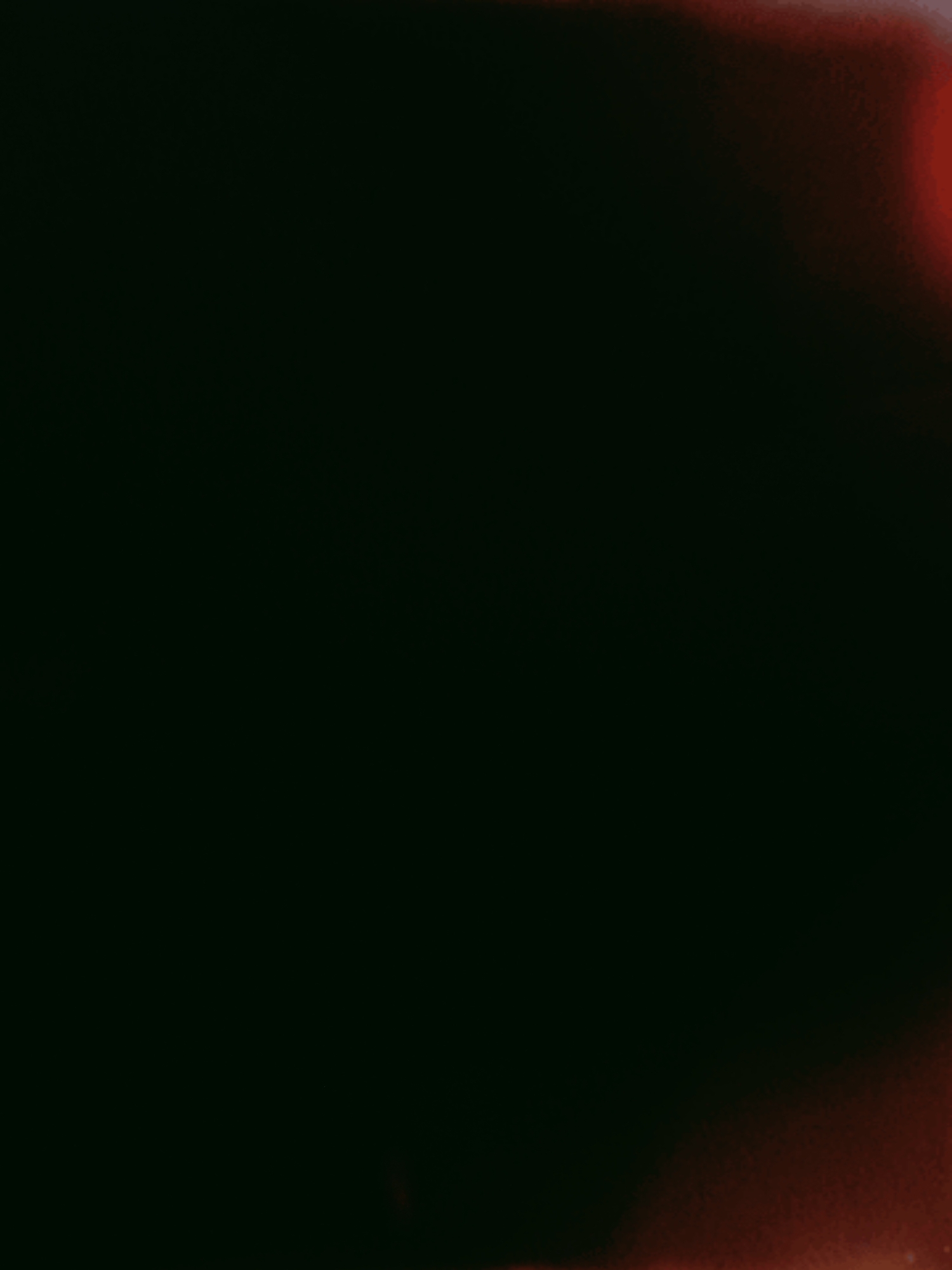 This is a dark, abstract image with a prominent gradient of red and orange light illuminating from the right side, fading into blackness towards the left. There are no discernible people, subjects, objects, or actions visible. The scene is devoid of any recognizable environmental features, making it impossible to determine a specific location within Shimanovsk, Russia or any other place.