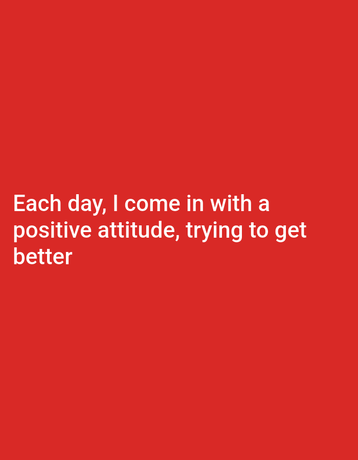 A close-up, medium shot captures white text on a solid red background. The text reads: "Each day, I come in with a positive attitude, trying to get better." The image appears to be a digital graphic or a photograph of text on a plain colored surface. There are no discernible geographical landmarks or environmental features to identify a city or location.