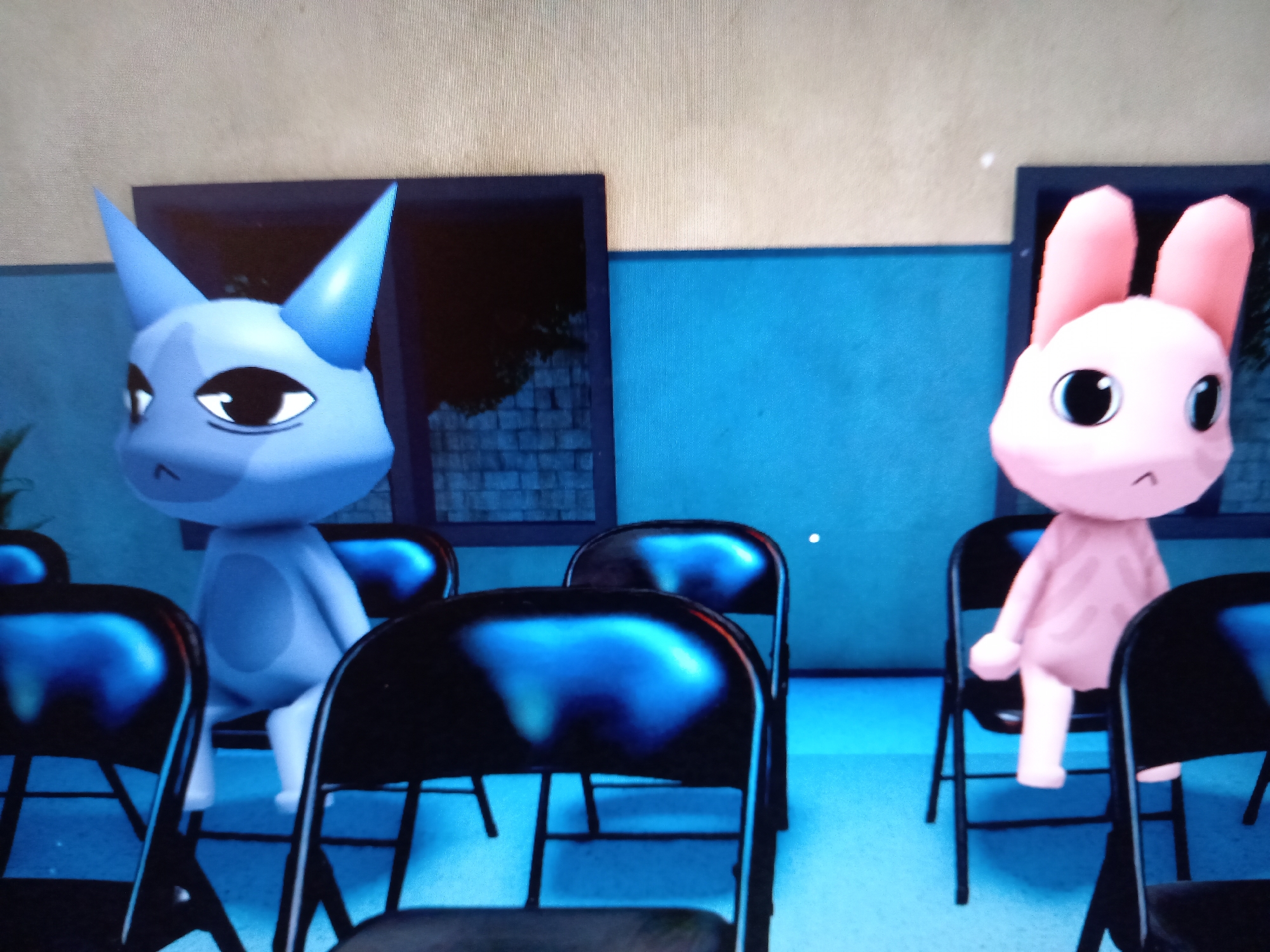 The image depicts two cartoon-like characters, one blue and cat-like with large pointed ears and almond-shaped eyes, and the other pink and rabbit-like with long ears and large round eyes. Both characters are seated in black folding chairs in what appears to be a room with a light beige wall and a blue-painted section below it. The blue character is on the left, and the pink character is on the right, with several empty chairs between them and in the foreground. The background shows dark openings that might be windows or doorways, revealing glimpses of a dark, possibly outdoor scene with some brick texture. The floor is a light blue. There is no visible indication of the location being in the city of Rudny, Kazakhstan.