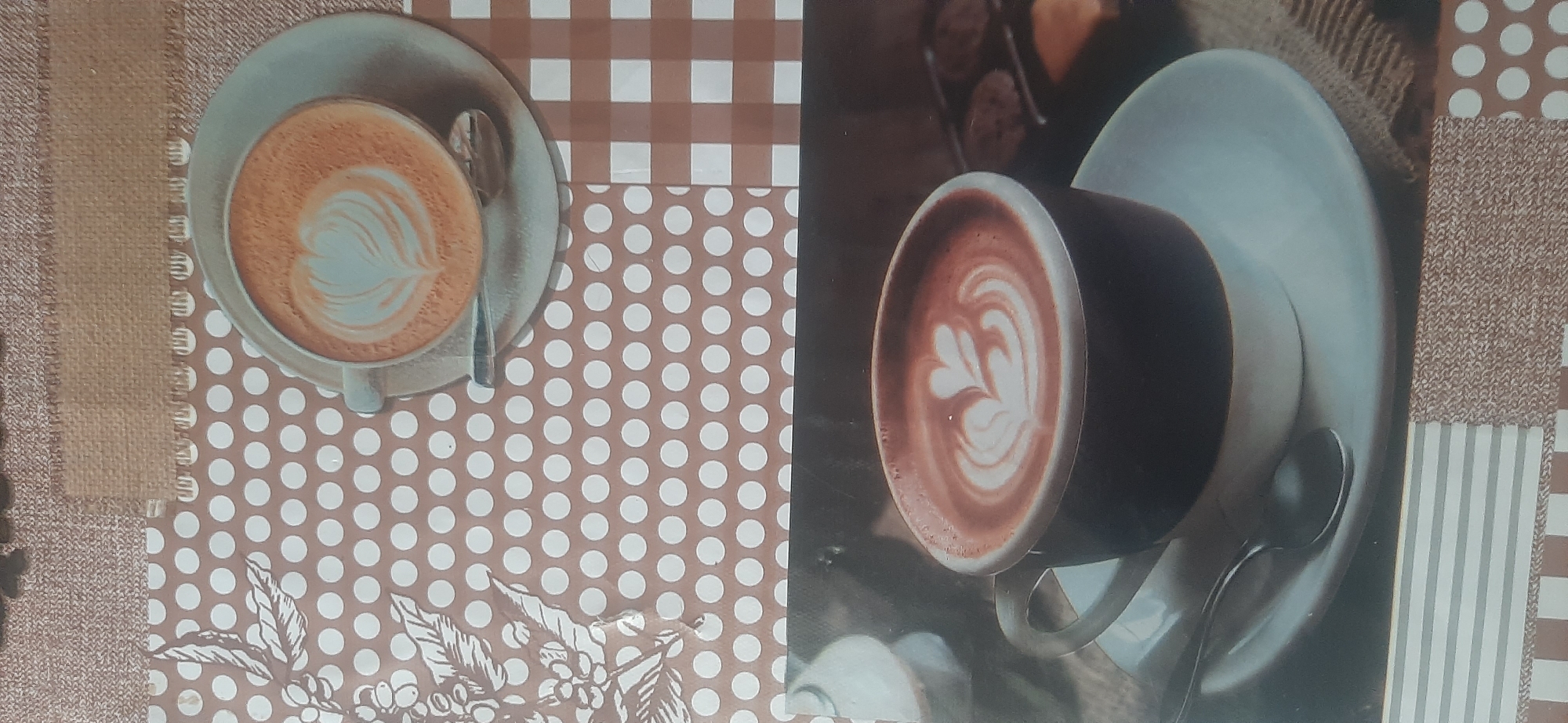 The image displays a close-up view of two cups of coffee with latte art. The top cup is a lighter shade, featuring a heart-shaped design on its frothy surface. The bottom cup, larger and darker, also showcases intricate latte art with a heart motif. Both cups are set against a backdrop with a patterned design that incorporates dots and checks, reminiscent of a kitchen backsplash or placemat. There are no people visible in the image, and no specific urban or natural environment is depicted. The overall scene is static and focuses solely on the coffee. The location in Yessentukskaya, Russia is not discernible from the visual information provided.