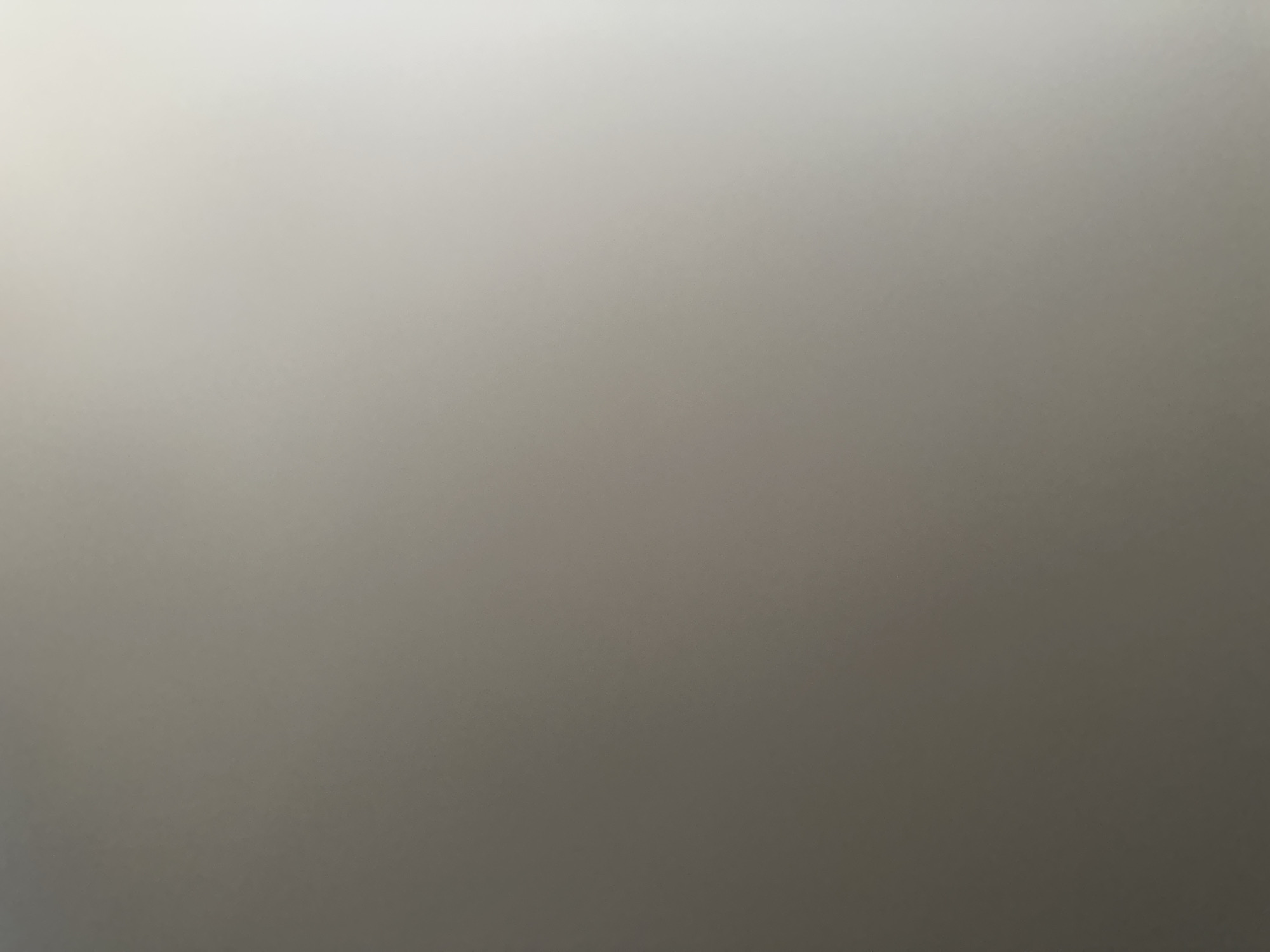 This media file is a full-frame, slightly out-of-focus photograph with a gradient of light. The top portion of the image is a bright, almost white-grey, which gradually darkens towards the bottom, becoming a medium grey. There are no discernible subjects, objects, or scene elements visible, nor any text. The image appears to be an abstract representation of light and shadow or a blurred background. The location context of Belgrade, Serbia, does not provide any discernible cues within the image itself. There is no activity or event taking place, and no details regarding time of day, weather, or emotions can be inferred.