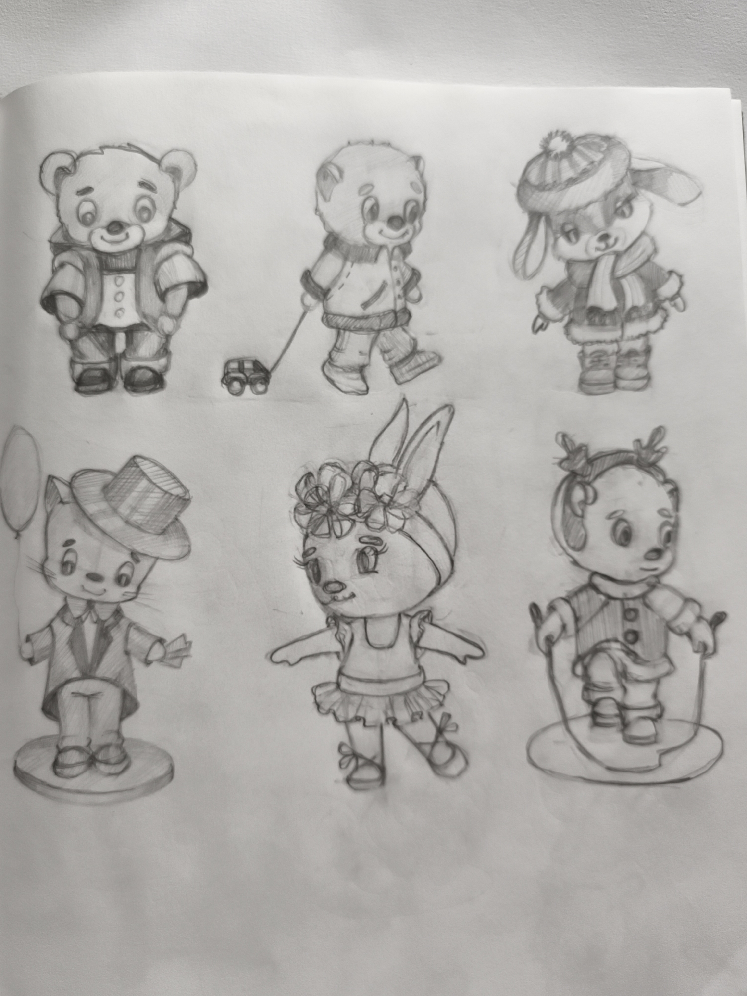 The image is a pencil sketch of six cartoon animal characters arranged in two rows of three. The characters are whimsical and appear to be toys or illustrations for a children's book. The top row features a bear in a jacket, a bear pulling a toy car, and a rabbit in winter attire. The bottom row depicts a cat in a tuxedo and top hat holding a balloon, a rabbit dressed as a ballerina, and a character resembling a bear or dog with reindeer antlers, skipping rope. The sketches are done on a plain white surface, likely paper. There are no elements in the image that suggest a location in Saint-Denis, France, or any specific urban environment. The overall scene is a collection of artistic drawings.
