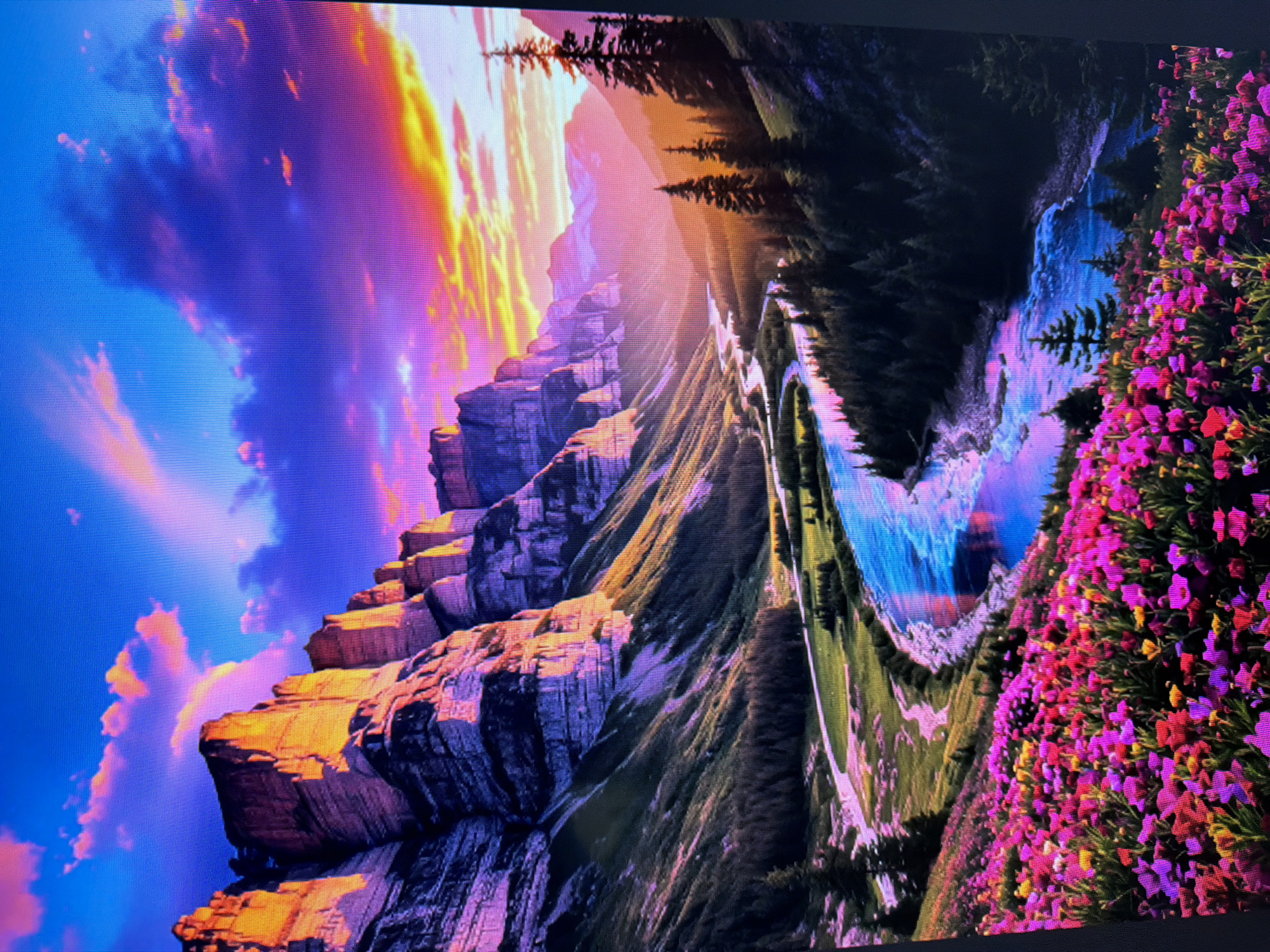 The image depicts a vibrant, idealized mountain landscape with a winding river, dense pine forests, and a foreground carpet of colorful wildflowers. The sky is a dramatic blend of blues, purples, and oranges, suggesting a sunset or sunrise. Towering, sun-kissed cliffs dominate the left side of the scene, casting long shadows over the valley. The river reflects the colorful sky, creating a shimmering, almost surreal effect. The foreground is densely packed with a variety of flowers in shades of pink, purple, red, and yellow. The overall impression is one of natural beauty and serenity. This image does not depict any specific location in Naberezhnye Chelny, Russia, as it appears to be an artistic or digital creation rather than a photograph of a real place.