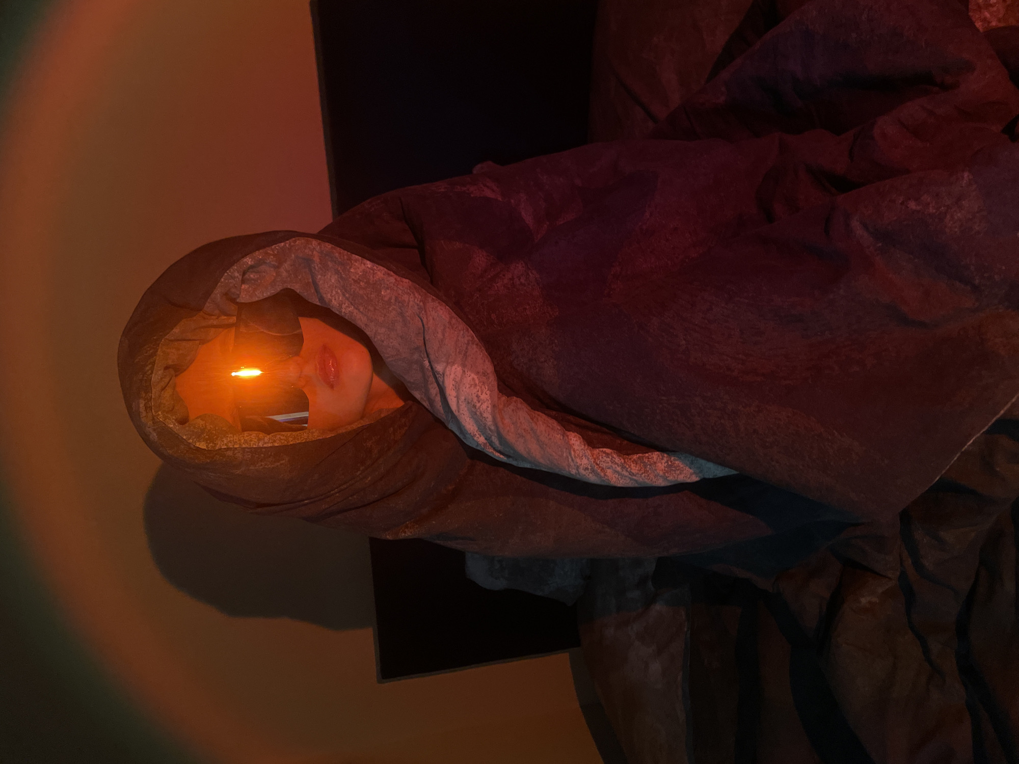 A statue of a hooded figure is depicted with an intense, bright light emanating from its eye area. The figure appears to be partially shrouded in dark cloth. The location is Подшивалово, Russia.