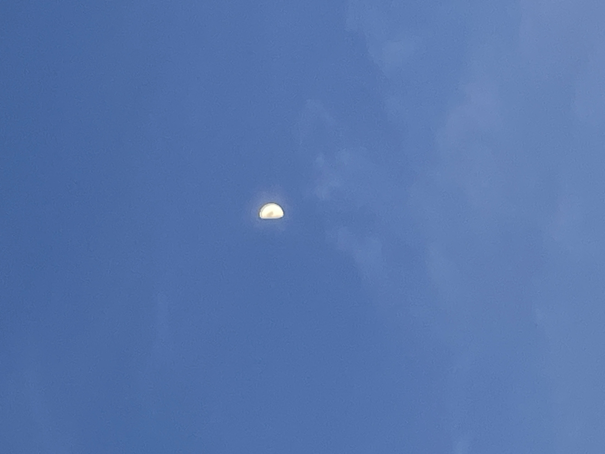 This media file depicts a clear blue sky with a small, bright object partially visible near the center. The object is spherical and illuminated, suggesting it could be the moon, a balloon, or another aerial phenomenon. The sky is a consistent shade of blue, indicating a daytime setting, likely with good weather and no visible clouds. The image appears to be taken from a ground-level perspective, looking upwards. No people or other distinct objects are visible in the frame, and there is no discernible text. The overall scene is simple and focused on the atmospheric conditions and the lone aerial object. The context of Bârnova, Romania, does not provide specific visual cues within the image itself but sets a geographical context for the photograph.