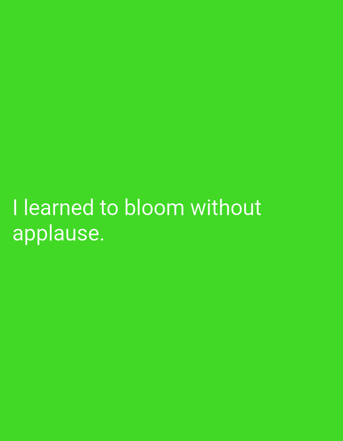 The image contains white text on a bright green background. The text reads: "I learned to bloom without applause." There is no information in the image that can be used to determine its location in Lassan, Pakistan.