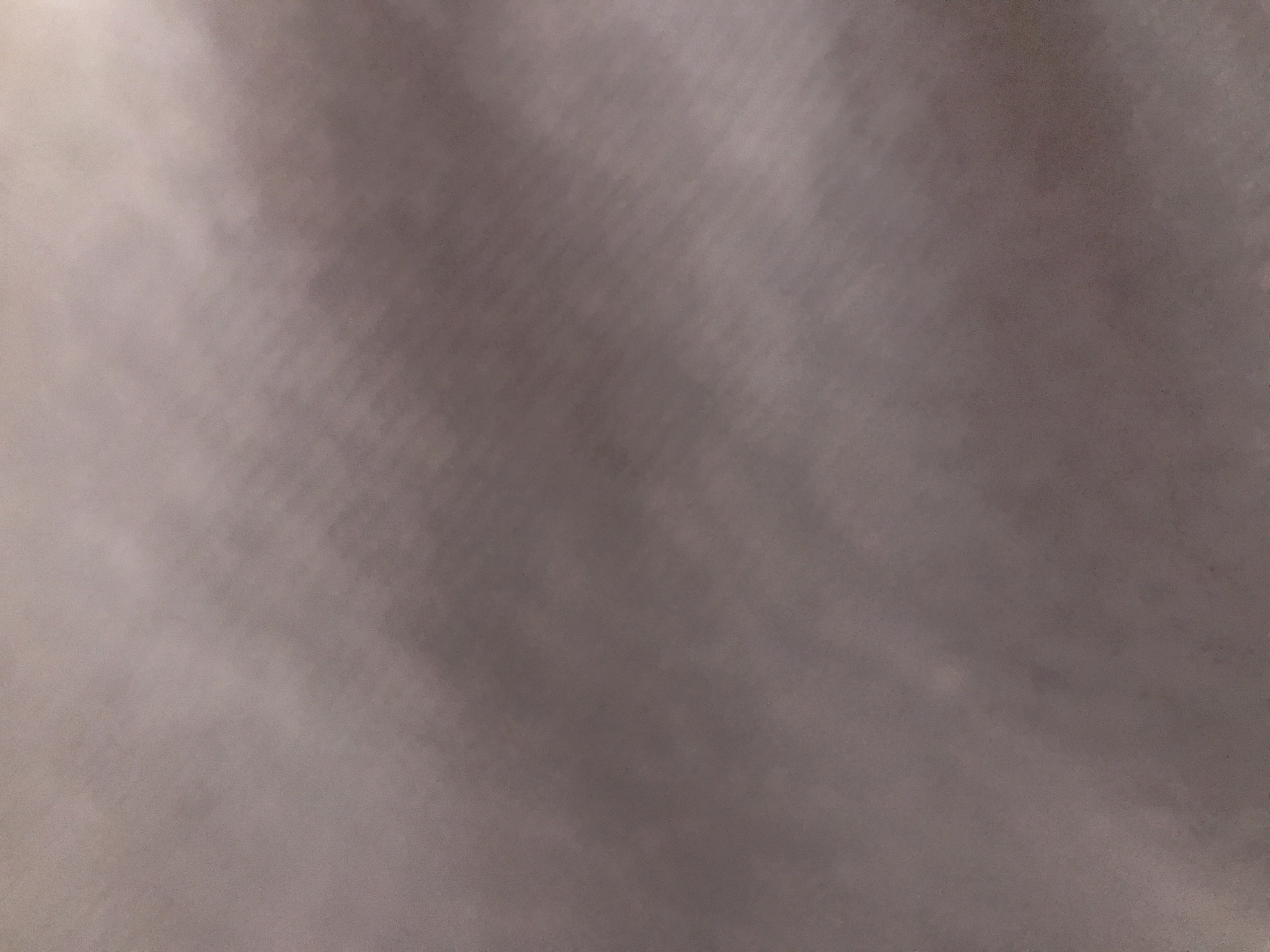 The image appears to be a close-up shot of a surface, possibly fabric or a wall, with an uneven, slightly blurred texture. The color is a muted, neutral tone, perhaps a gray or a light brown. No specific details indicate a location in Yerevan, Armenia, and there are no people or objects identifiable in the image.