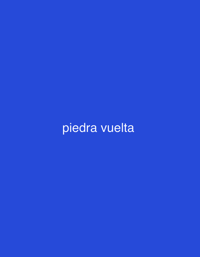The image displays a minimalist composition featuring white text centered on a solid royal blue background. The text, "piedra vuelta," is rendered in a clean, sans-serif font and is entirely in lowercase. No people, objects, or a discernible scene are depicted. The blue background is uniform and vibrant, serving as the sole visual element apart from the text. While the location context of Santa Ana, Venezuela is provided, the image itself does not contain any visual cues, landmarks, or specific details that would identify or allude to this geographical setting. The media file is a simple graphic emphasizing the Spanish phrase "piedra vuelta."