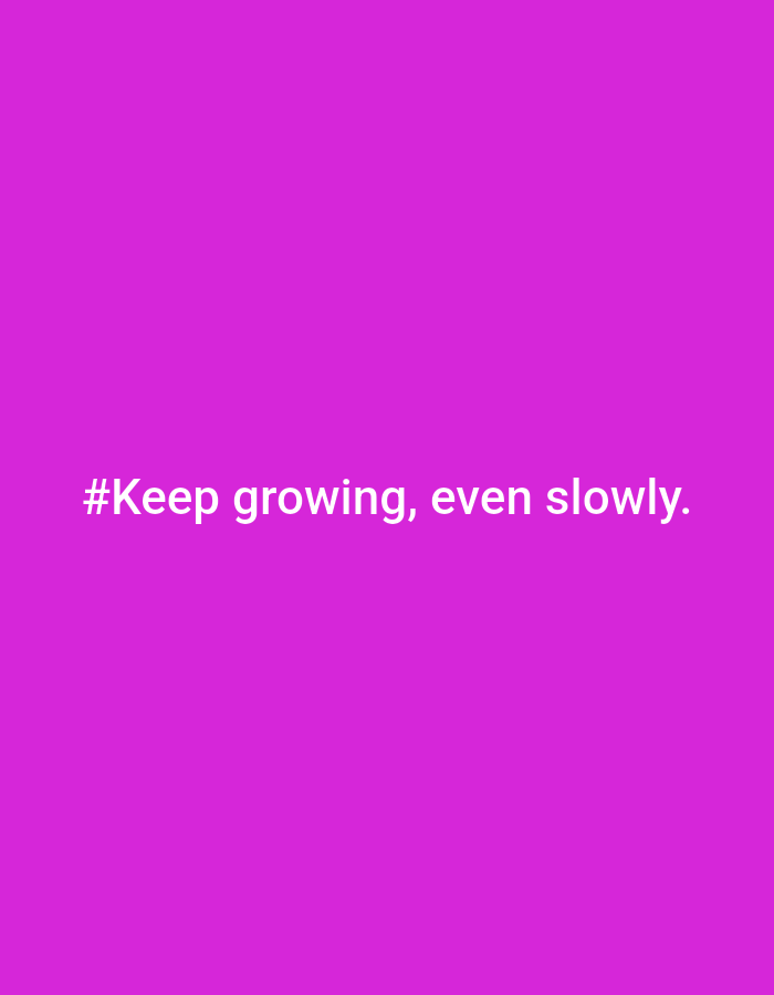 The image is a solid bright purple background with white text that reads "#Keep growing, even slowly." The text is centered horizontally and vertically on the image. There are no people, objects, actions, interactions, or environmental elements visible in the image. The location in the city of Ploso, Indonesia is not relevant to the content of the image.