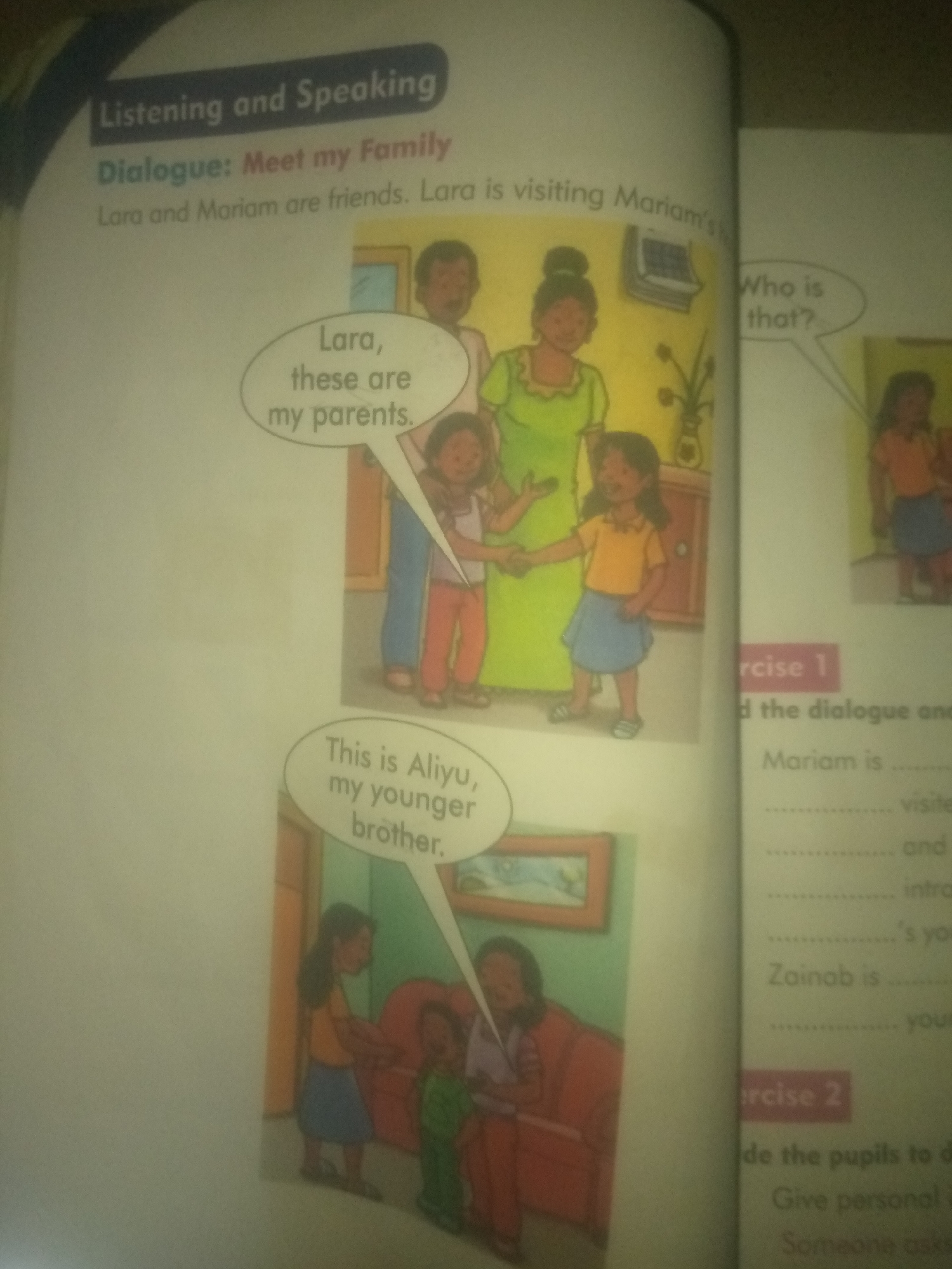 This image is a scan of an open book, featuring illustrations and text related to a dialogue titled "Meet my Family." The left page shows a scene with two girls, Lara and Mariam, interacting with a family. Lara is introducing her parents and younger brother. A speech bubble above Lara's parents reads, "Lara, these are my parents." Another speech bubble, near Lara's younger brother, says, "This is Aliyu, my younger brother." The family depicted includes a father, mother, Lara, and Aliyu.
The right page of the book contains text for "rcise 1" and "rcise 2," suggesting exercises for language learning. Under "rcise 1," there are fill-in-the-blank sentences related to a dialogue. Under "rcise 2," there are instructions for pupils. There is also a partial illustration of a girl in an orange top and blue skirt on the far right of the page, possibly related to the exercises.
There is no information in the image to indicate any specific location in Jauro Yinu, Nigeria. The content appears to be from an educational textbook.