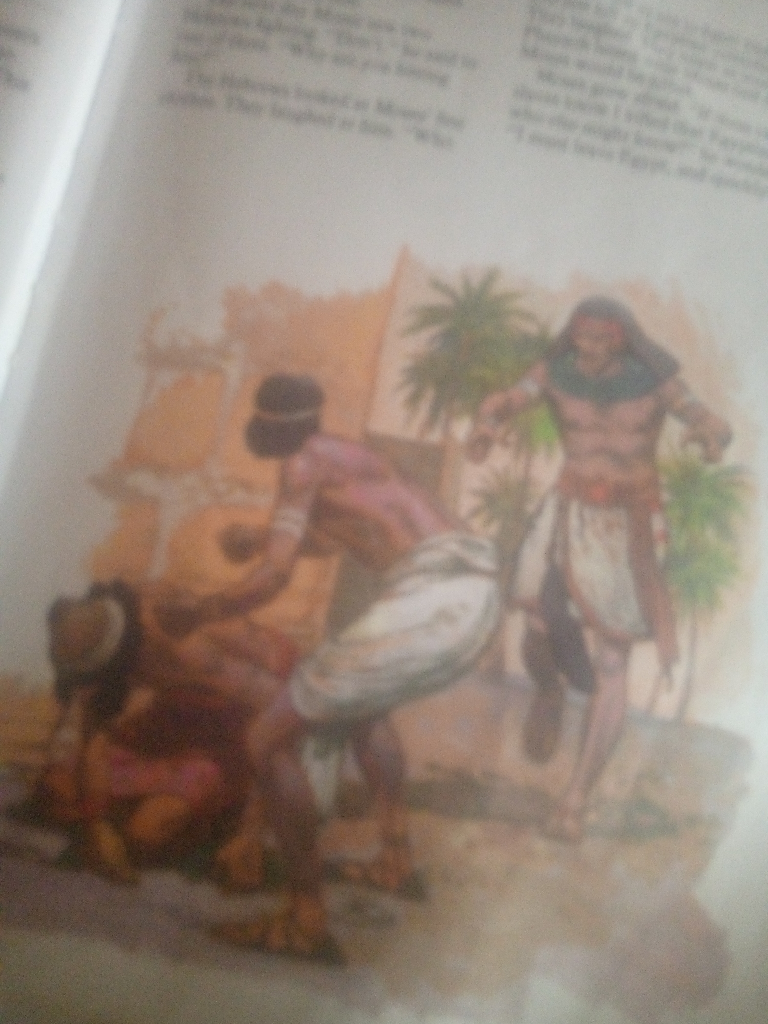 The image depicts a scene from a historical or religious text, illustrated with a painting. In the foreground, two figures are shown in a state of struggle or distress. One figure, appearing to be male, is lying on the ground, partially obscured. Another figure, also seemingly male, is positioned over him, with his arms extended. Both figures are dressed in attire suggestive of ancient times, with cloth wrappings around their waists and torsos. The background features architectural elements and palm trees, indicating an outdoor setting in a warm climate. The overall impression is one of conflict or a dramatic event. The text accompanying the image is partially visible, suggesting it is from a book or document. There is no indication or context provided in the image or accompanying text that places the scene in the city of Jauro Yinu, Nigeria.